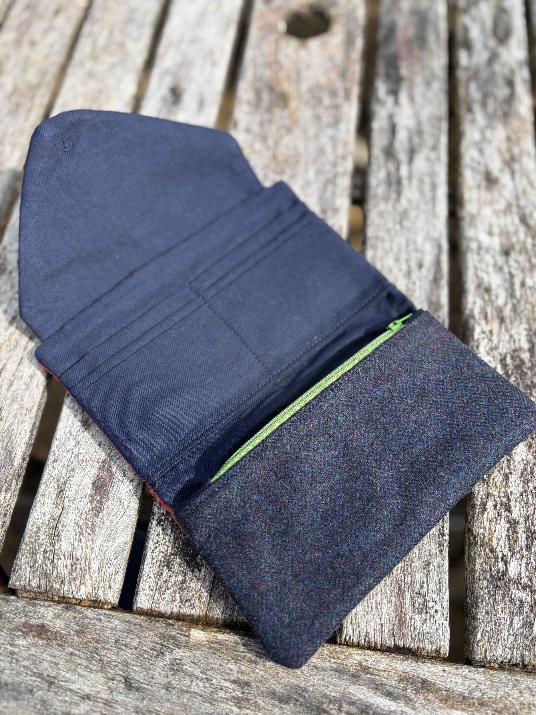 Inside view of Scottish tartan clutch bag showing organised pockets, card slots, zip compartment and blue lining