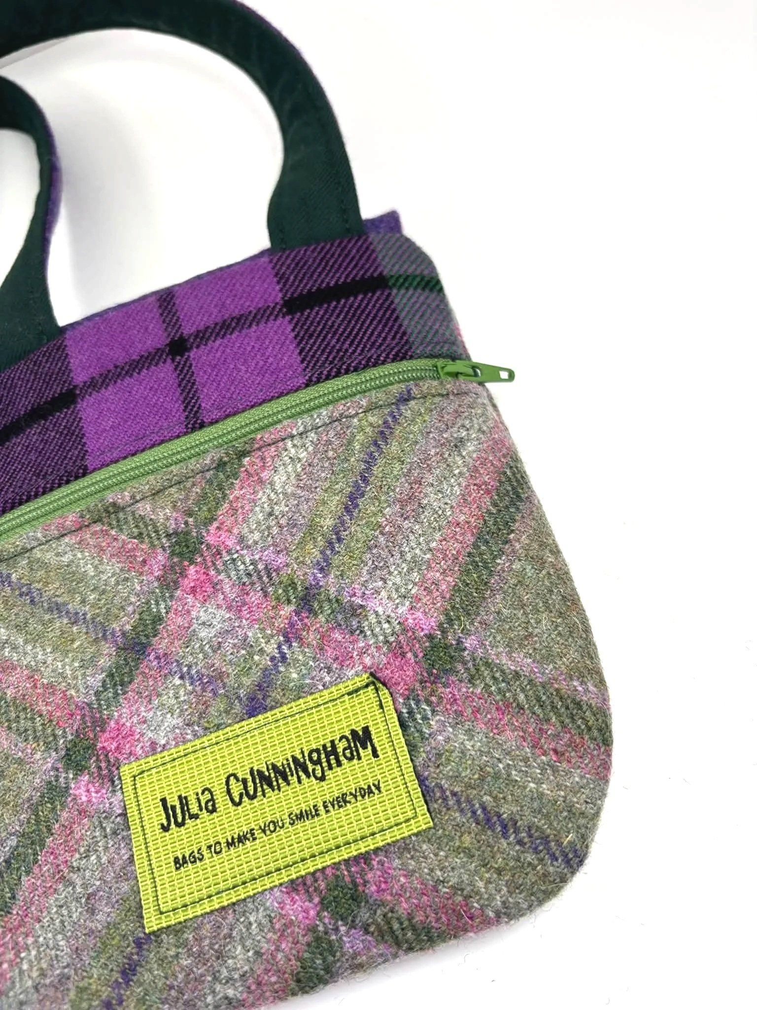 image of green zip and Julia Cunningham label on back of a cross body phone bag in purple and green tweed and tartan