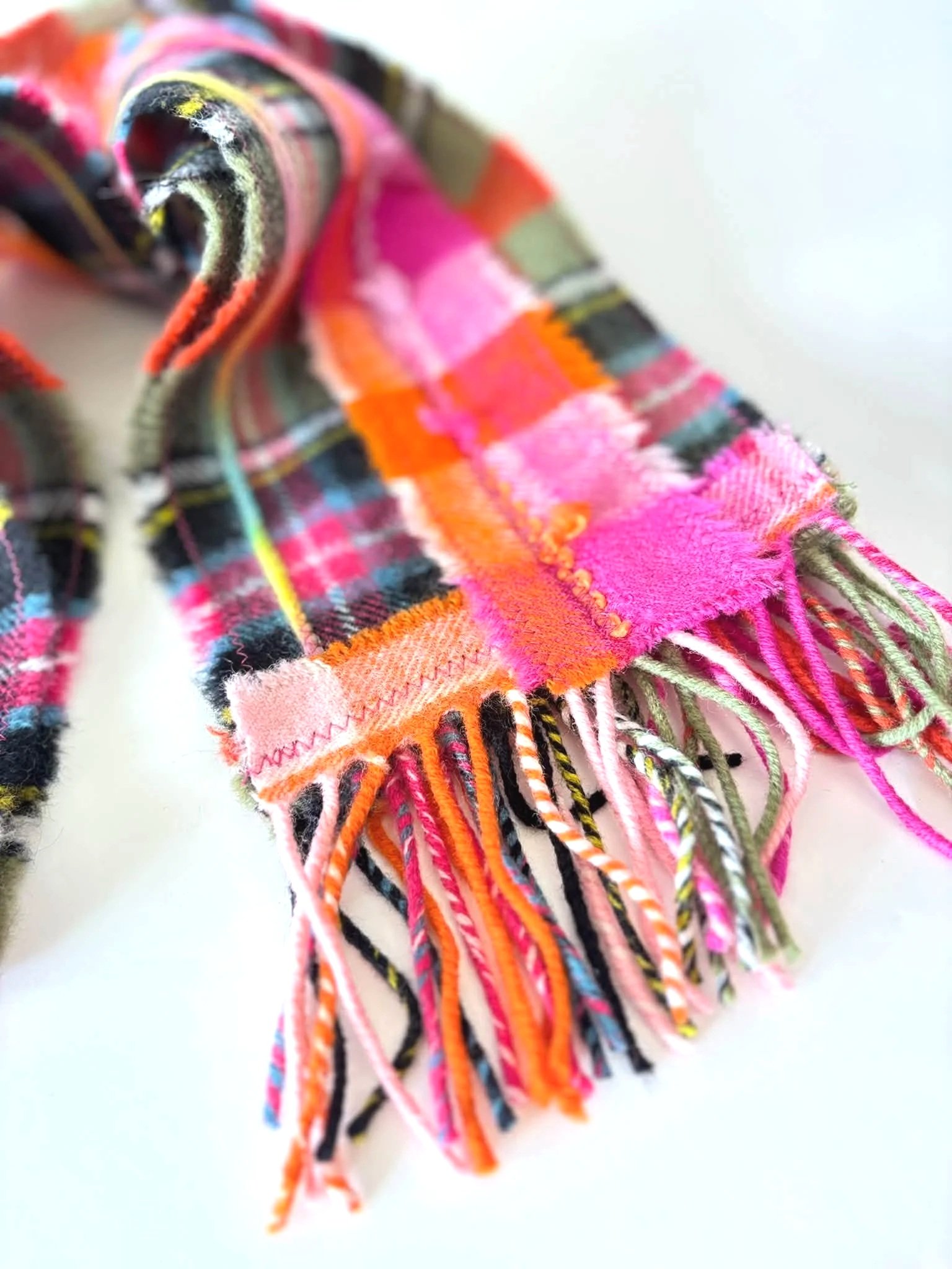 detailed view of a pink and green scarf showing fringe detail