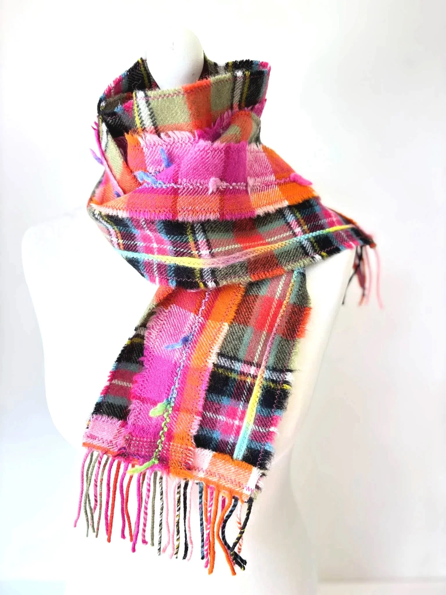 handmade green and pink Scottish woven scarf with added texture wrapped around neck of mannequin