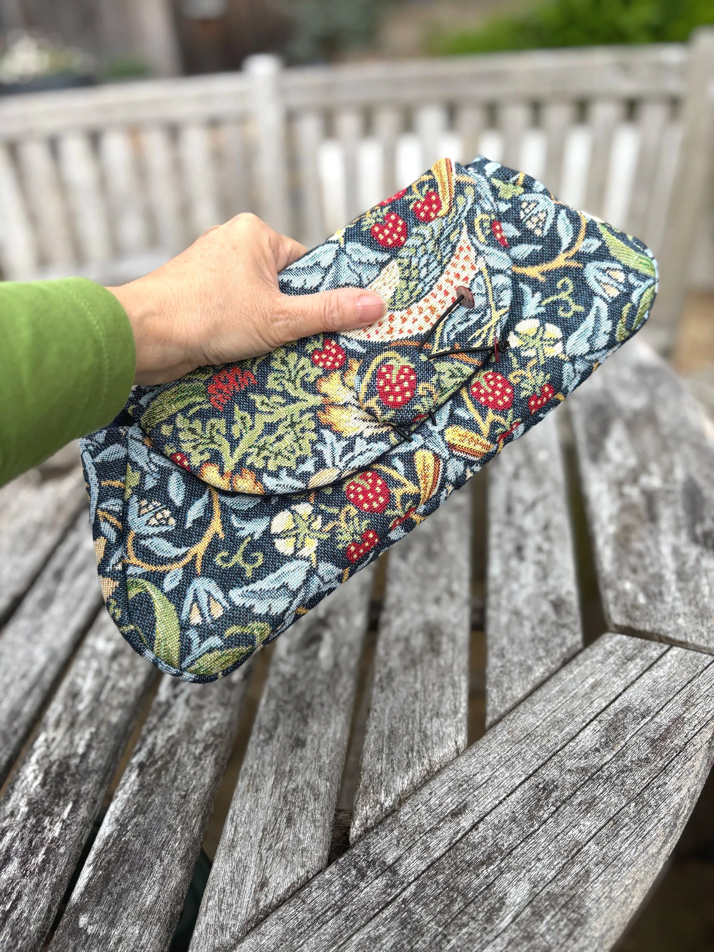 floral brocade clutch bag in blue front view with hand for size