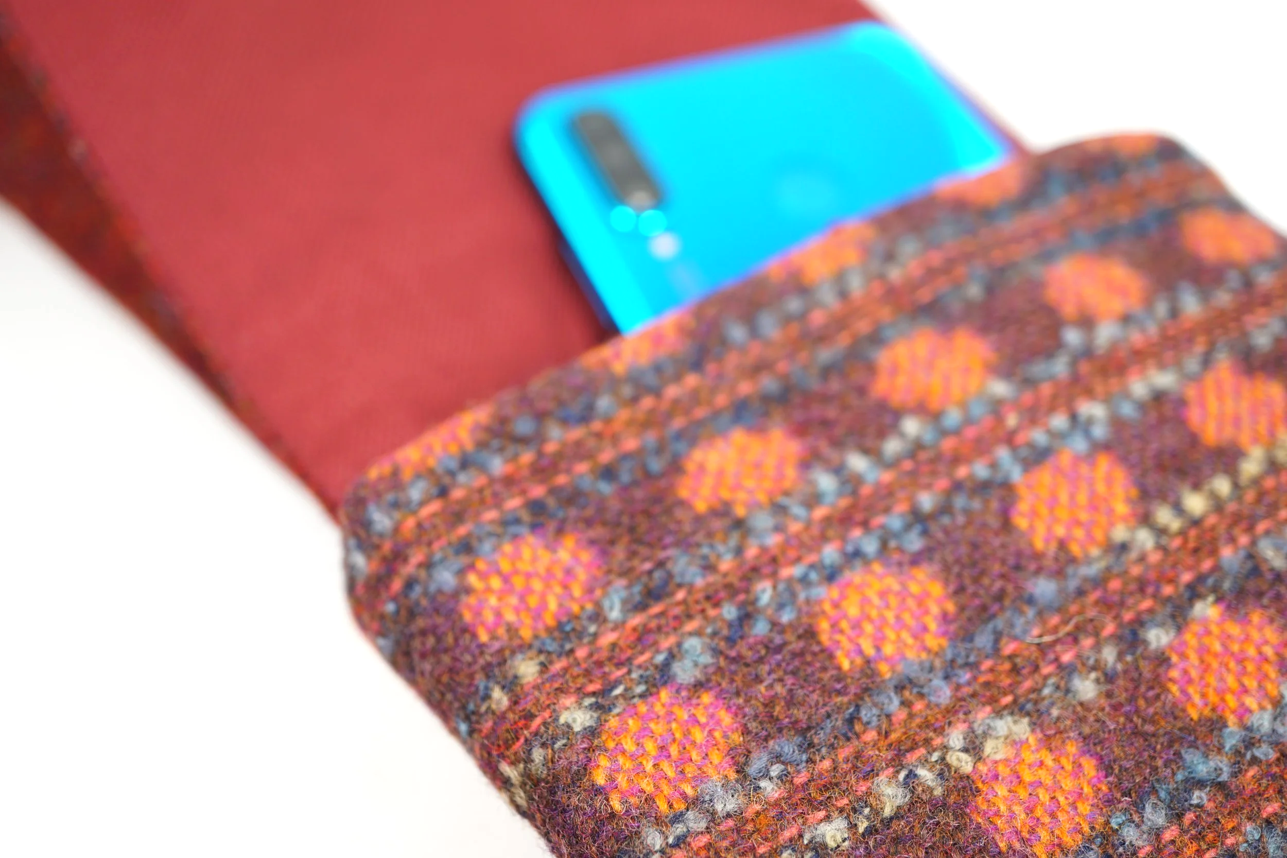 phone inside a cross body phone bag tweedling brown and red