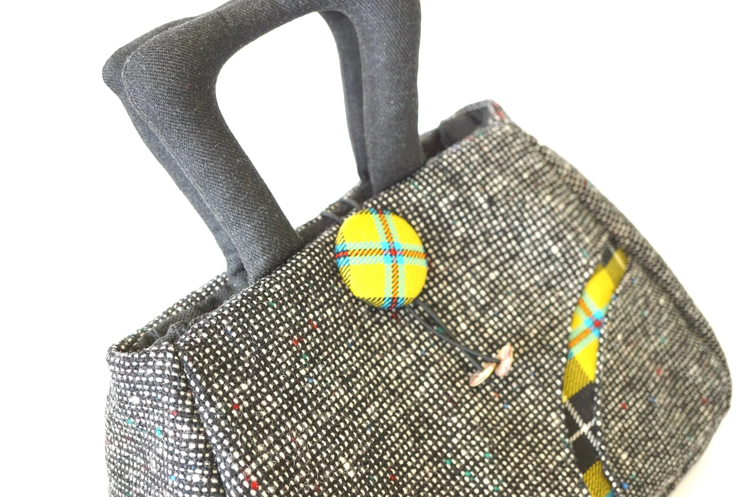Close‑up of padded hand‑carried handles on the black Scottish tweed Fantoosh handbag.