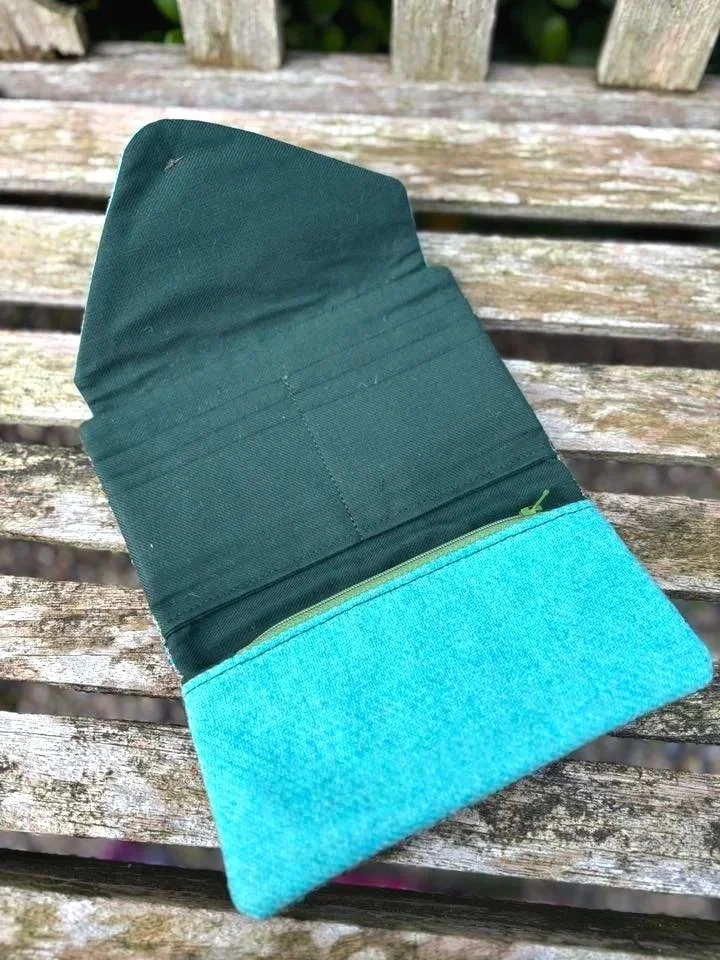 Interior of handmade Scottish clutch purse showing card slots, zip pocket and green lining by Julia Cunningham