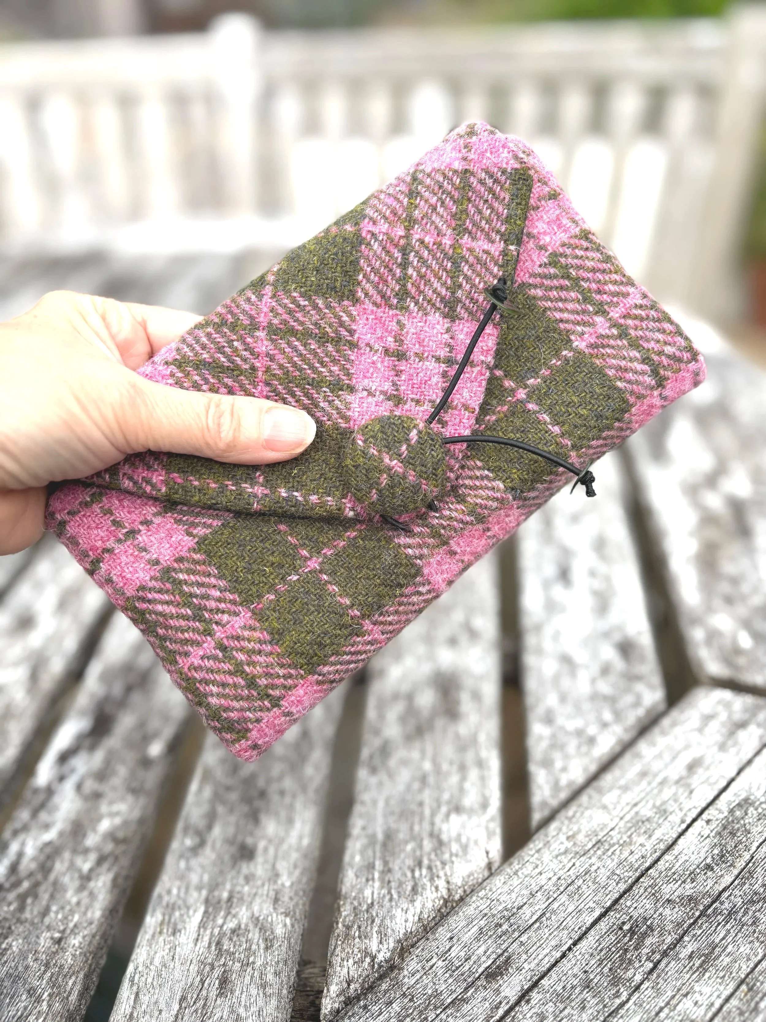 harris tweed clutch bag in pink and olive hand showing size