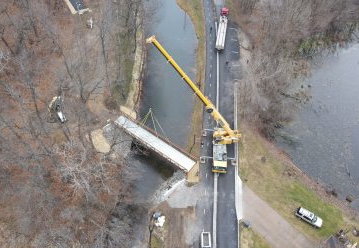 A giant crane and steady hands set 14,000-pound footbridge into place