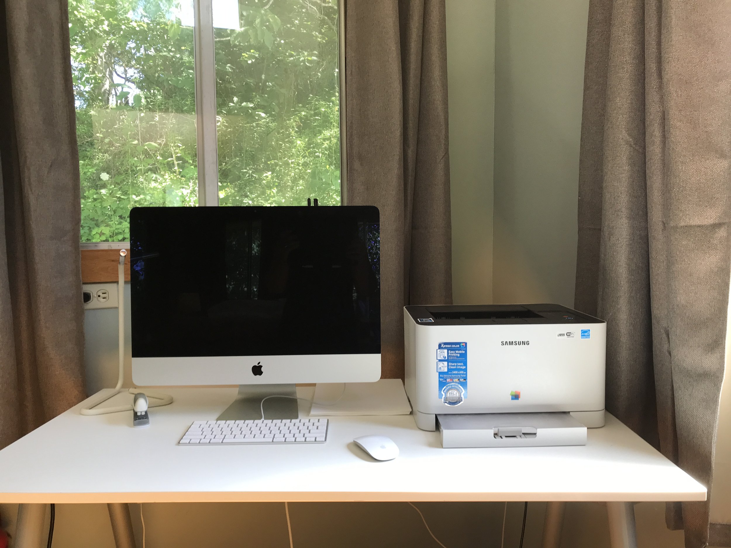  The office has a desk, chair, light,  air Laser printer, and an iMac computer that can be used with a guest login or as a high-resolution monitor. 