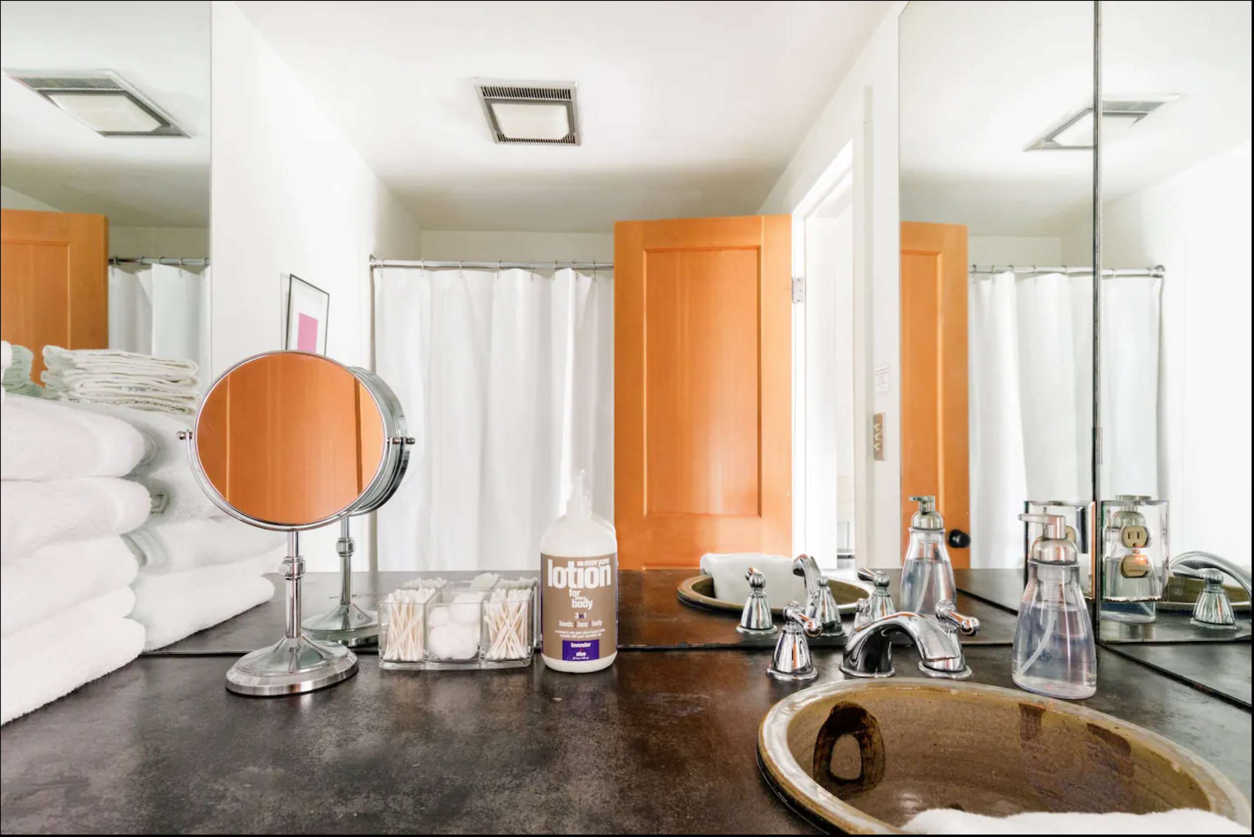 The second en suite bath has a shower/tub combo, makeup mirror, and a sink by Cynthia Bringle. 