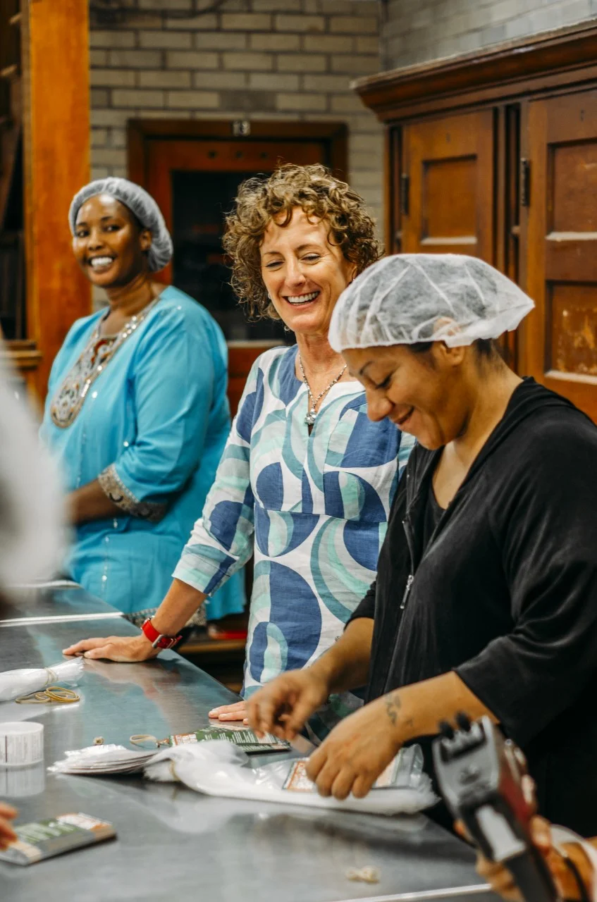 Tamra Ryan (center), CEO of Women’s Bean Project with workers Abok (left) and Emilia (right.)