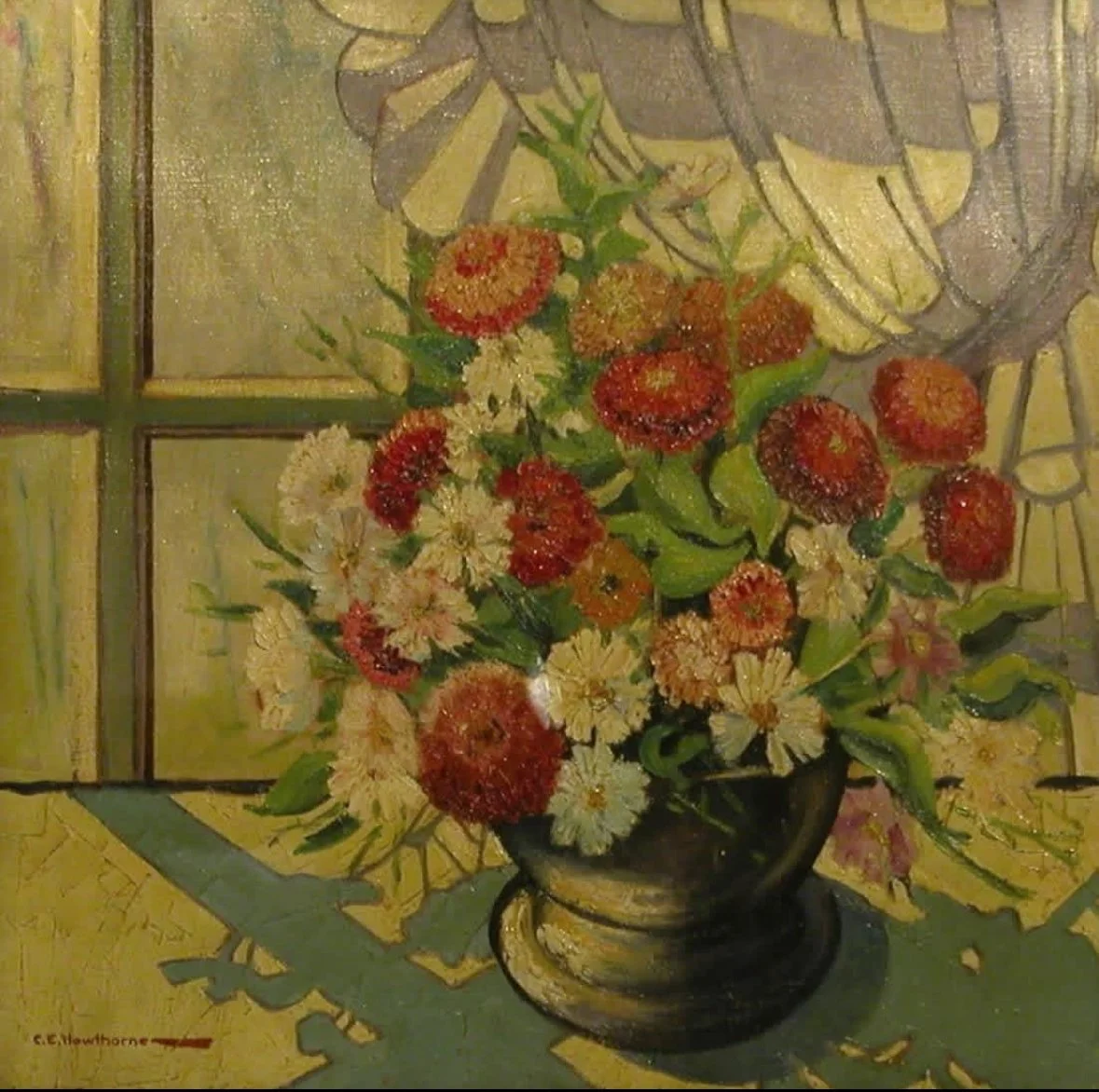 A still life painting of a floral bouquet in a dark vase placed on a table with a decorative cloth, featuring mostly daisies and round red and orange flowers, set against a window with stitched panes.
