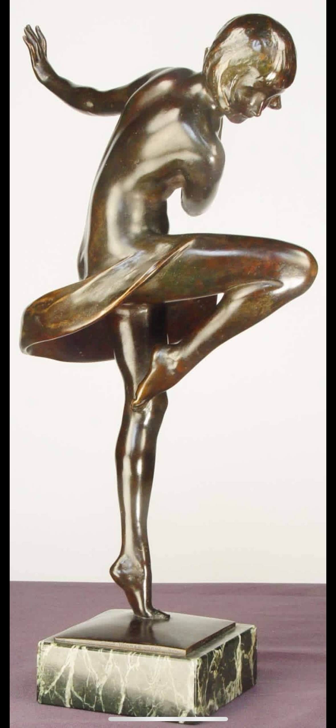 Brass sculpture of a ballet dancer in a pose, standing on one leg with the other leg bent and raised, on a marble base.