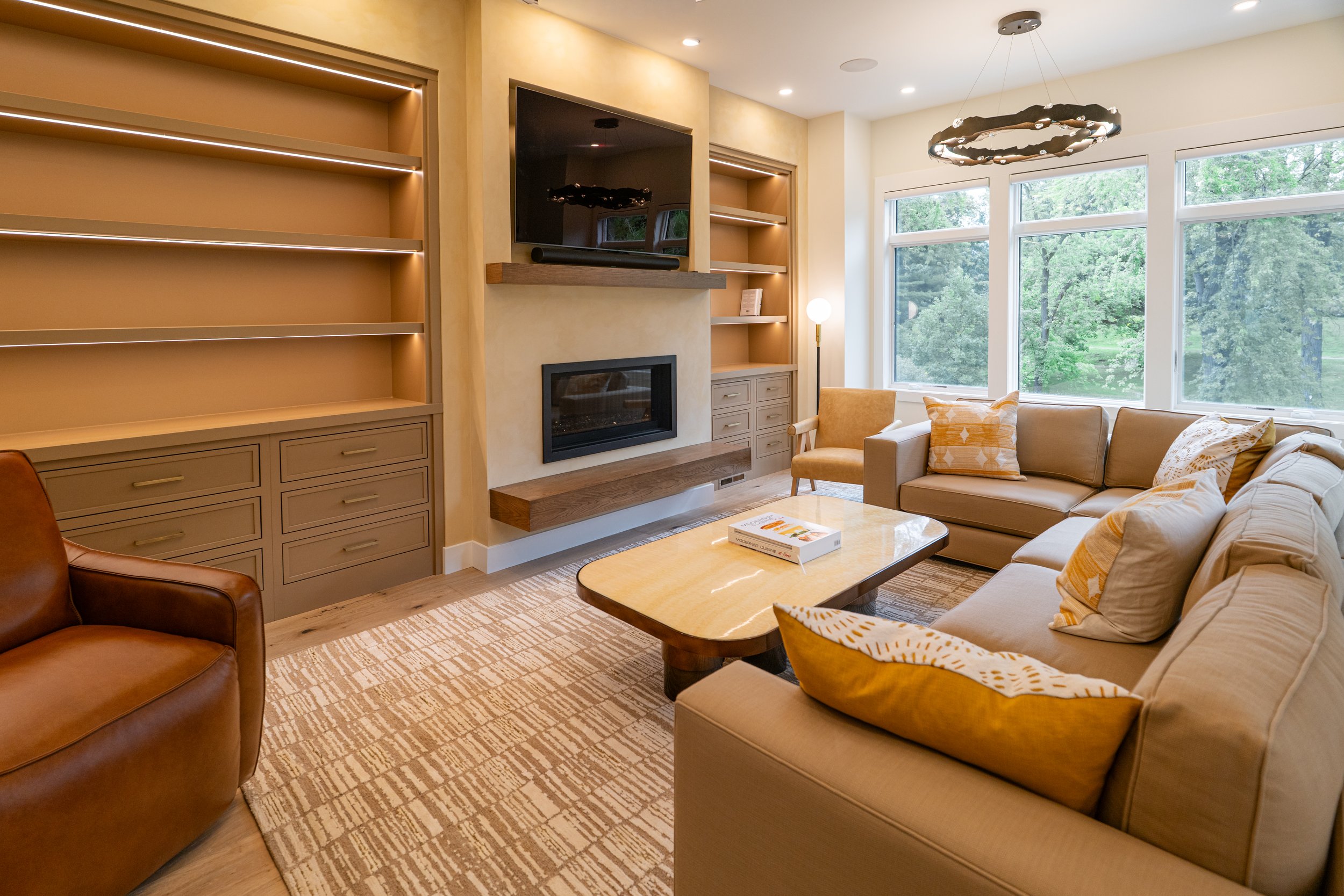 Beautiful updated living room with limewash tv wall, custom built in shelving surrounding the fireplace and tv cutout.
