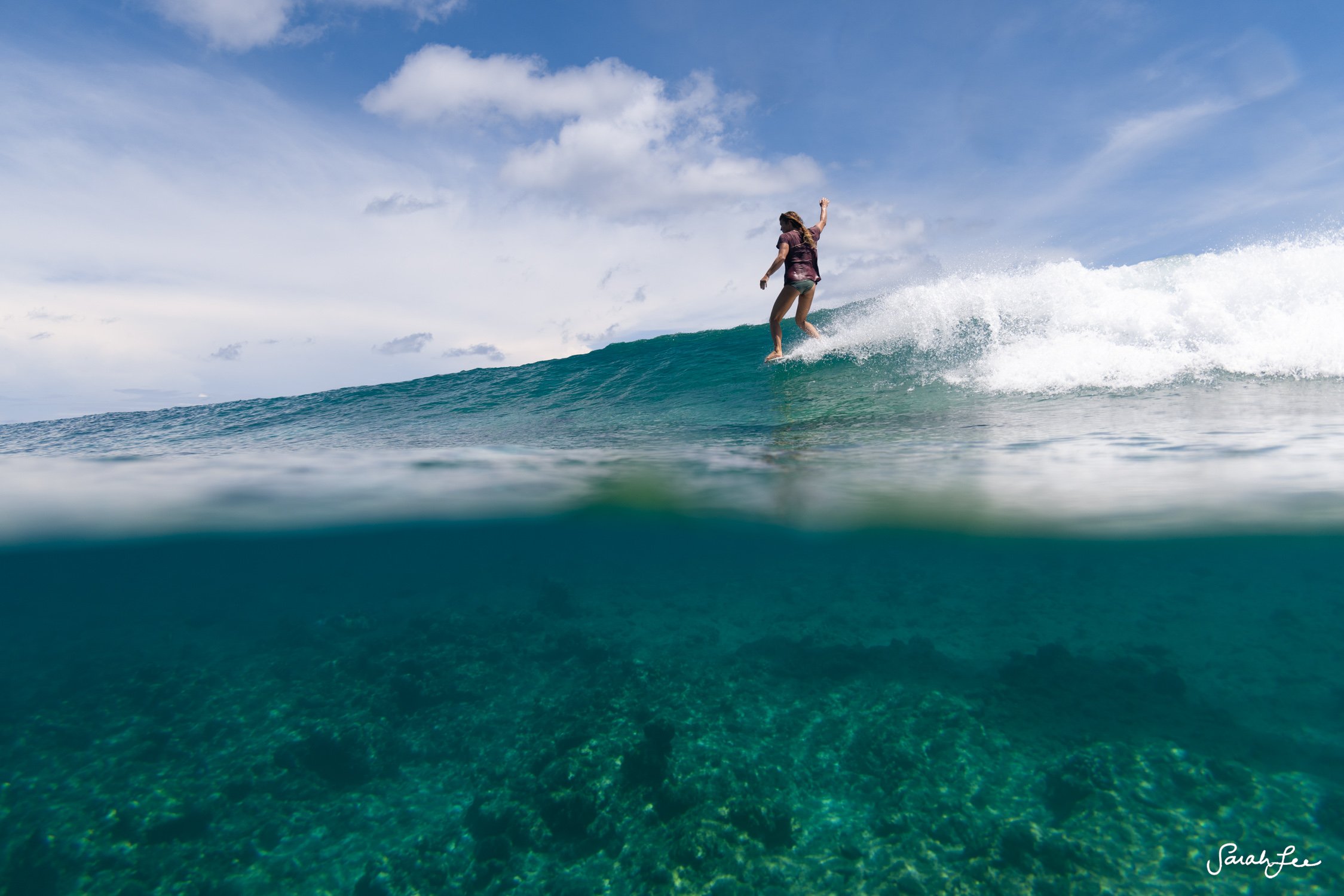 Leah Dawson hang five in crystal clear blue water.