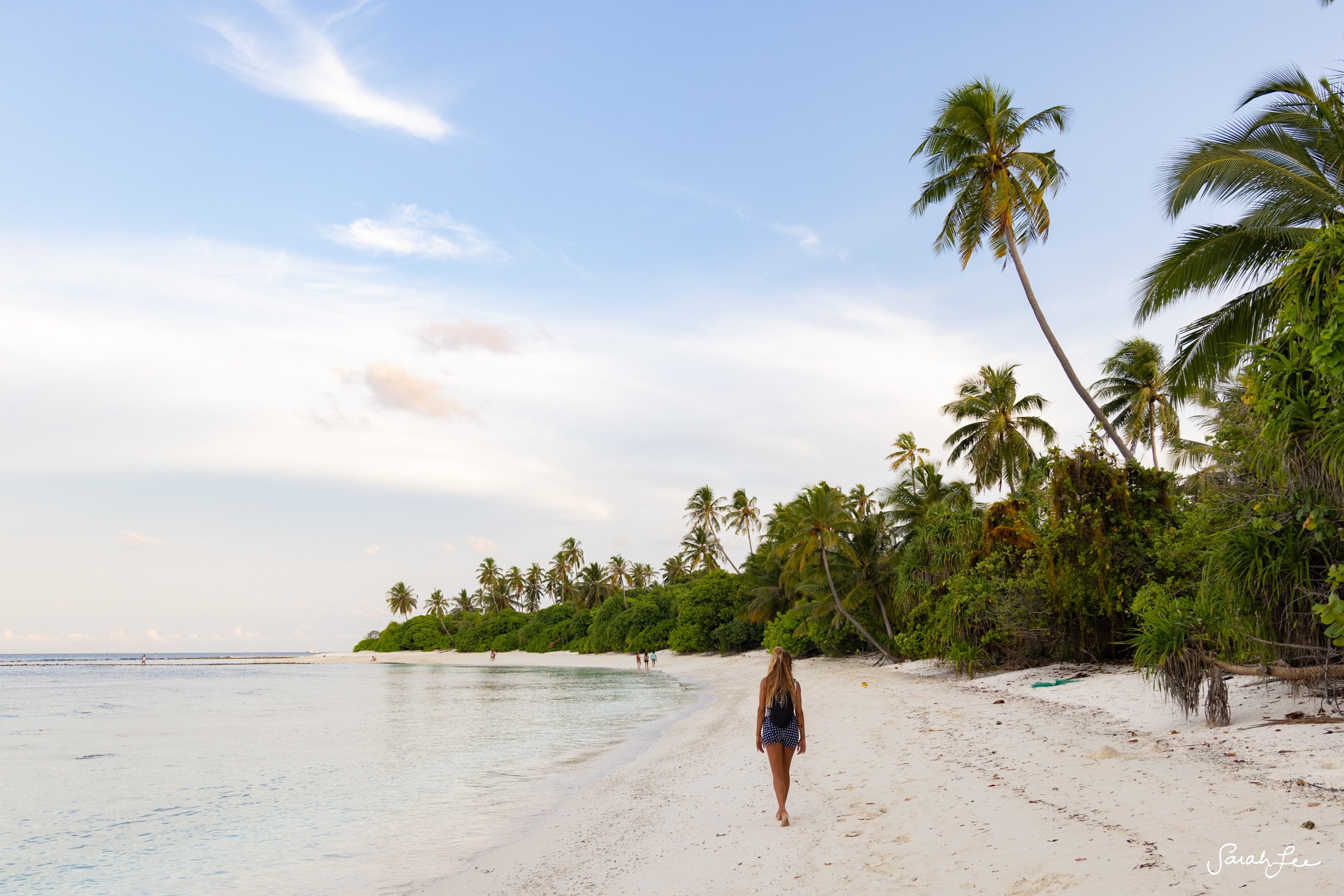 Exploring an empty white sand beach with palm trees in the Maldives