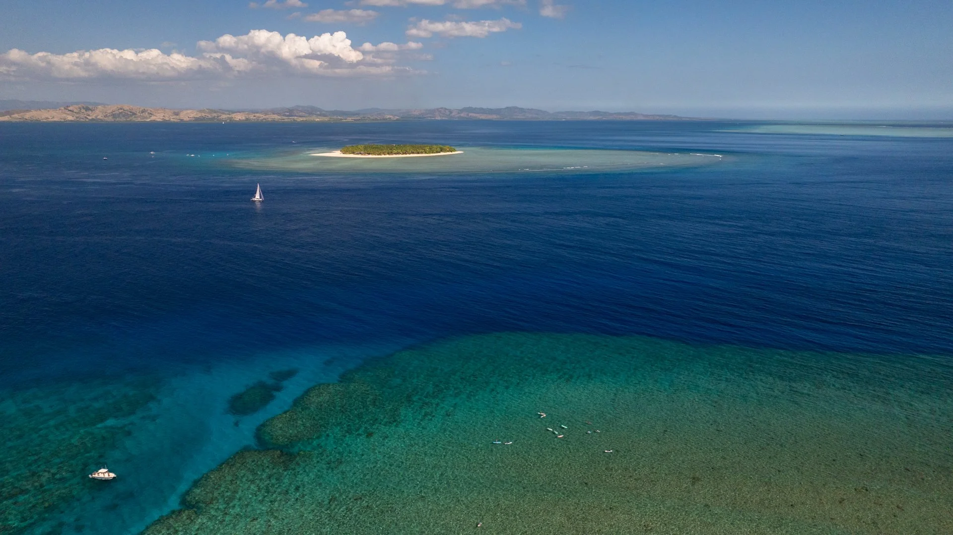  sailboat crossing the channel between namotu and tavarua islands in fiji 