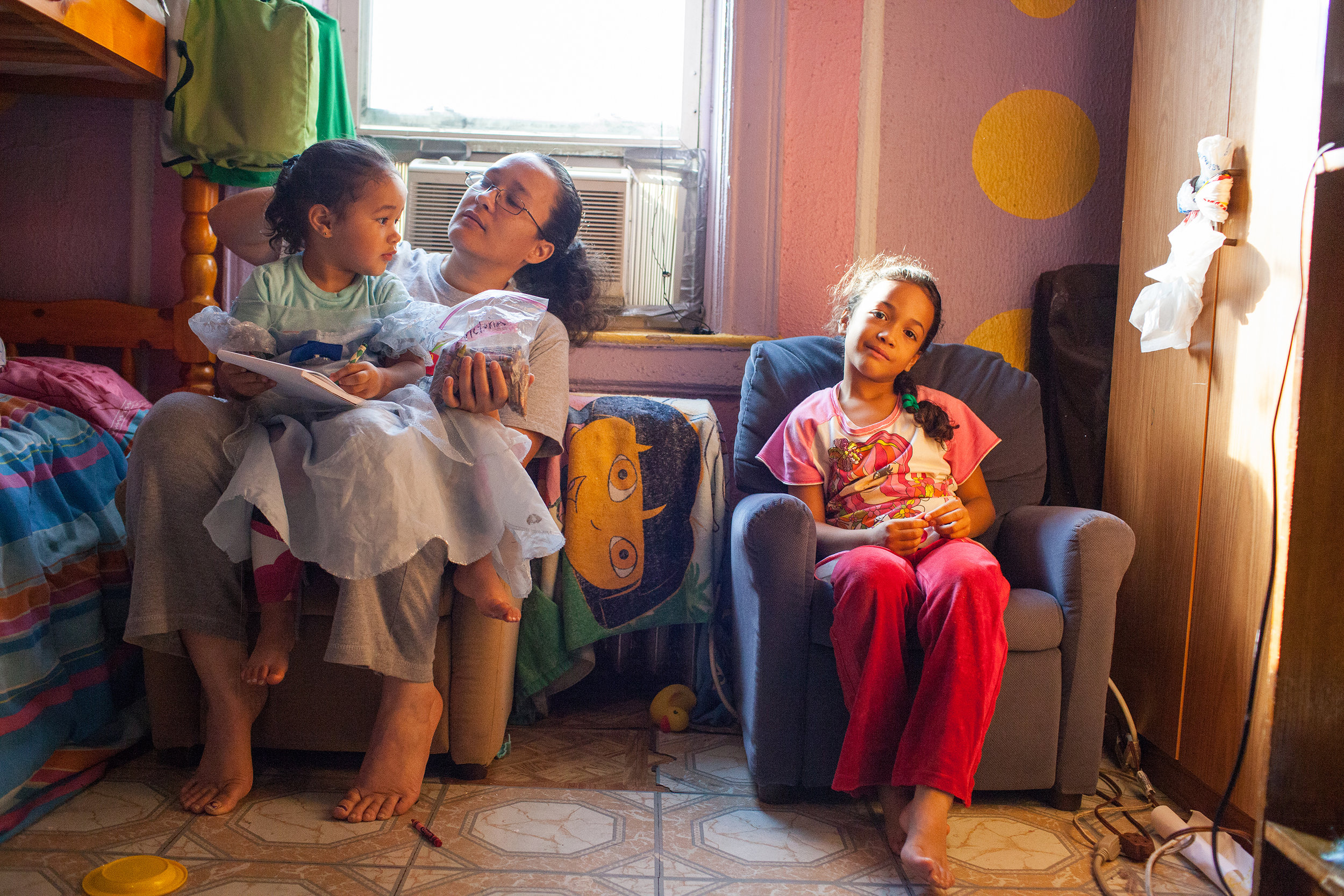 Dina Garcia is a 42-year-old mother of two little girls and a 26-year-old son with three children of his own. She’s resourceful and navigates a challenging life with upbeat resignation. She lives in the Bronx and works in a grocery store bakery on the Upper West Side. Meanwhile, the girls go to a charter school near her mother’s apartment on the Lower East Side. Dina, a life-long minimum-wage earner, visits pantries for groceries and sometimes goes to a soup kitchen that offers family dinners. 