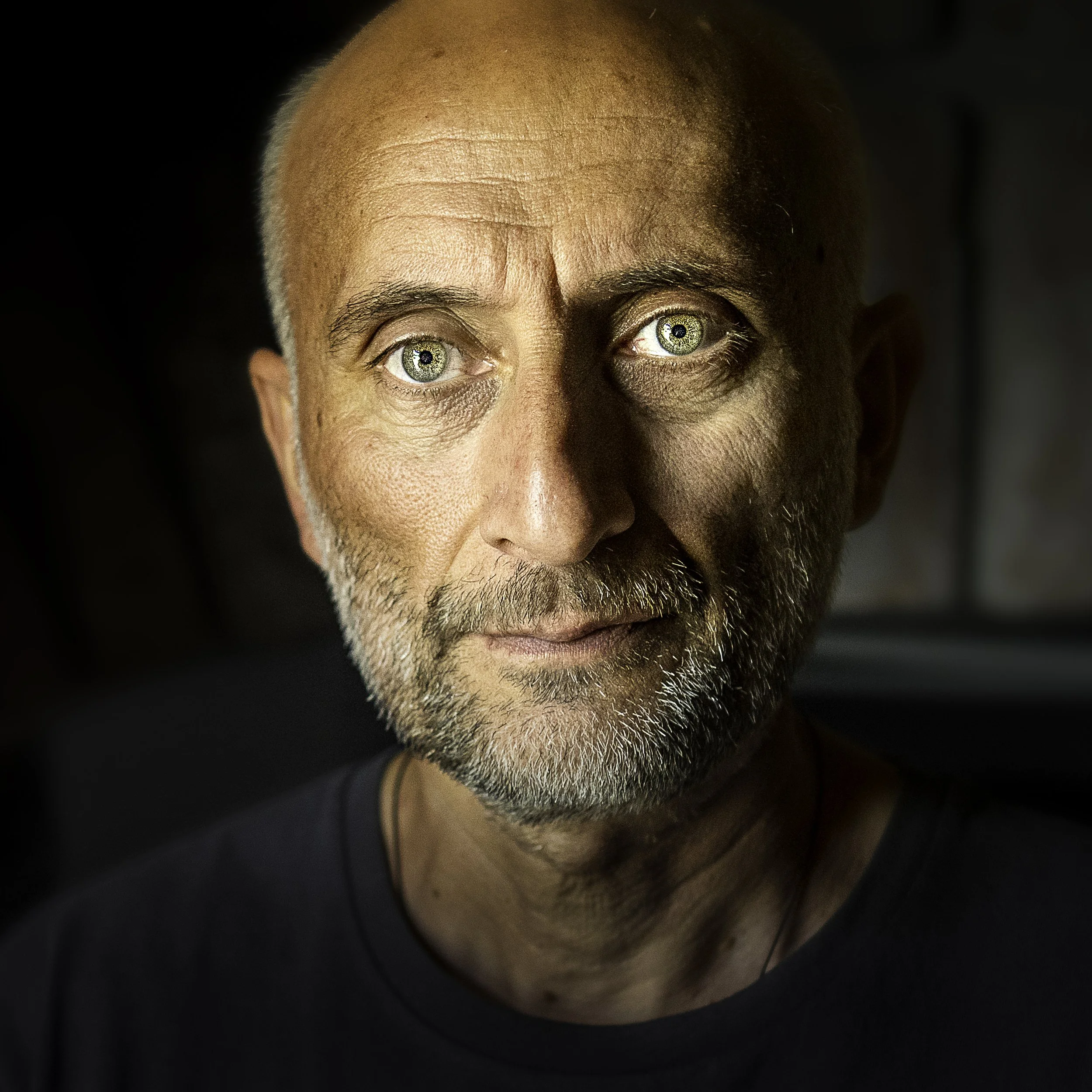 Close-up of Georgia wine legend Iago Bitarishvili's face with green eyes, light stubble, and a serious expression.