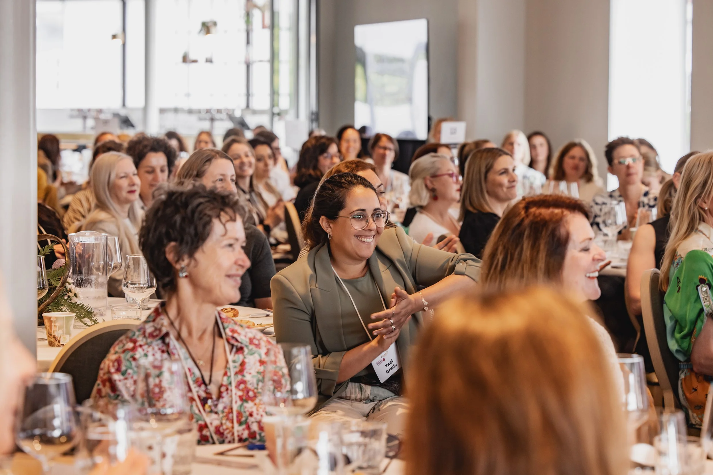 A crowd of attendees at the Australian Women in Wine Symposium watch and listen to a keynote speaker at the 2025 event.