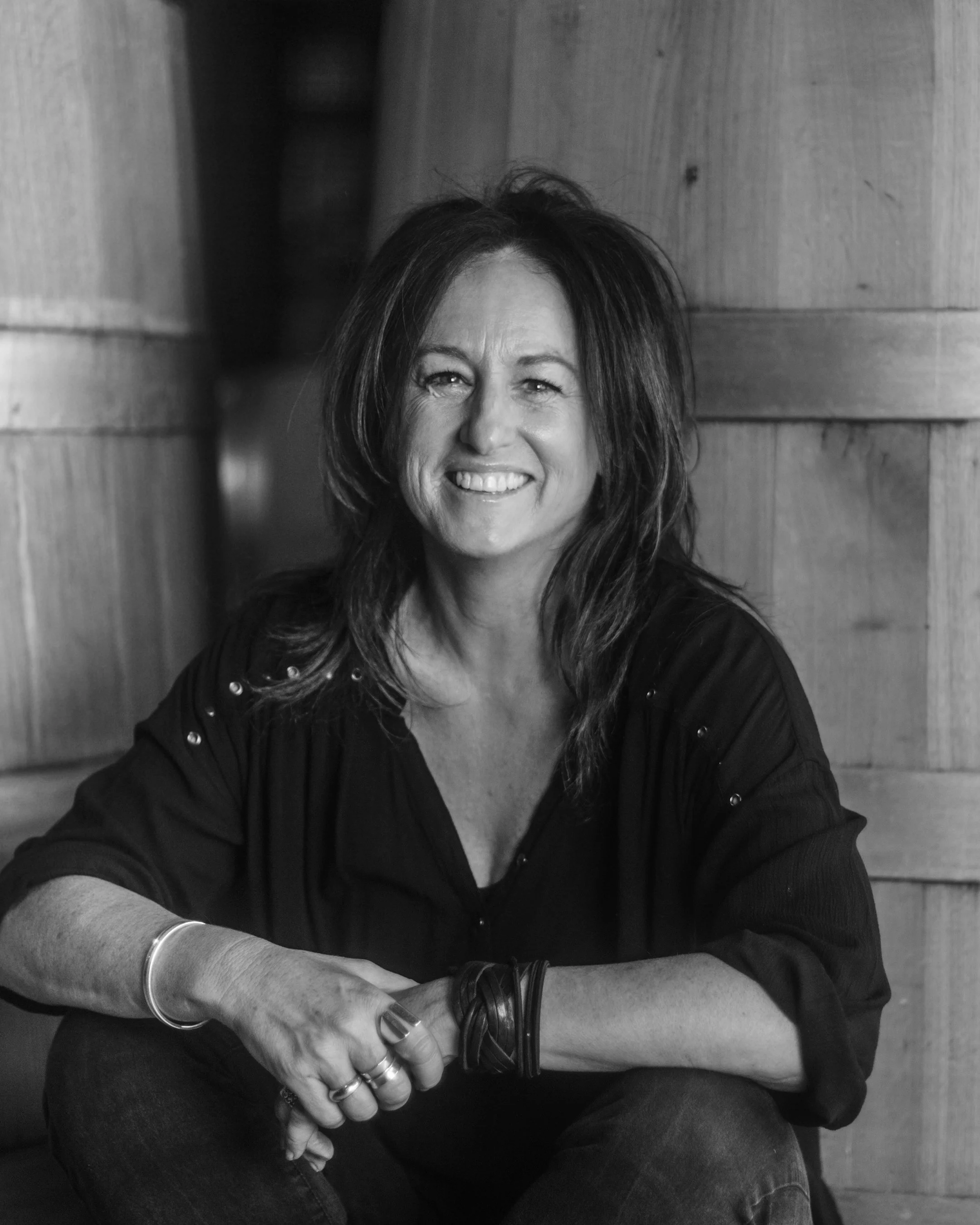 Virgina Willcock sitting against wine barrels at Vasse Felix in Margaret River.