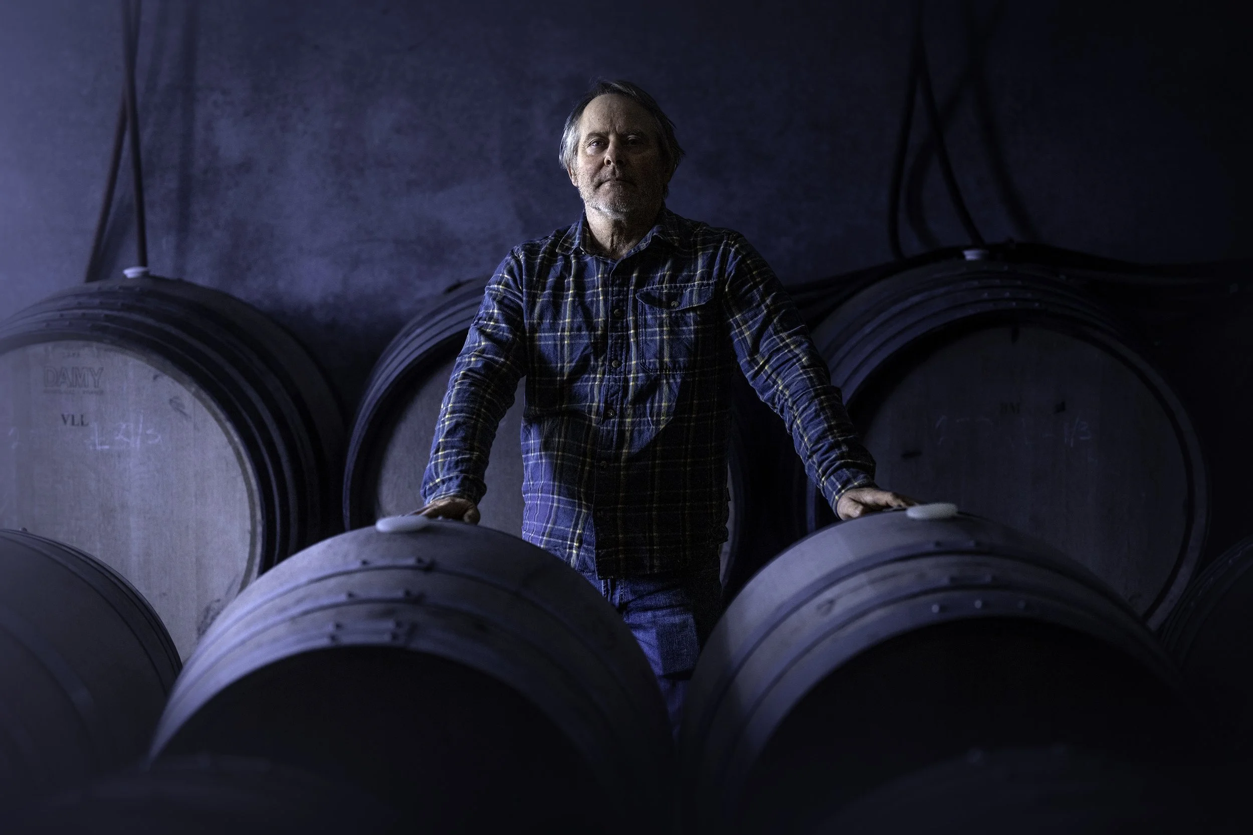 Steve Lubiana of Stefano Lubiana Wines stands in the cellar and looks straight at the camera.