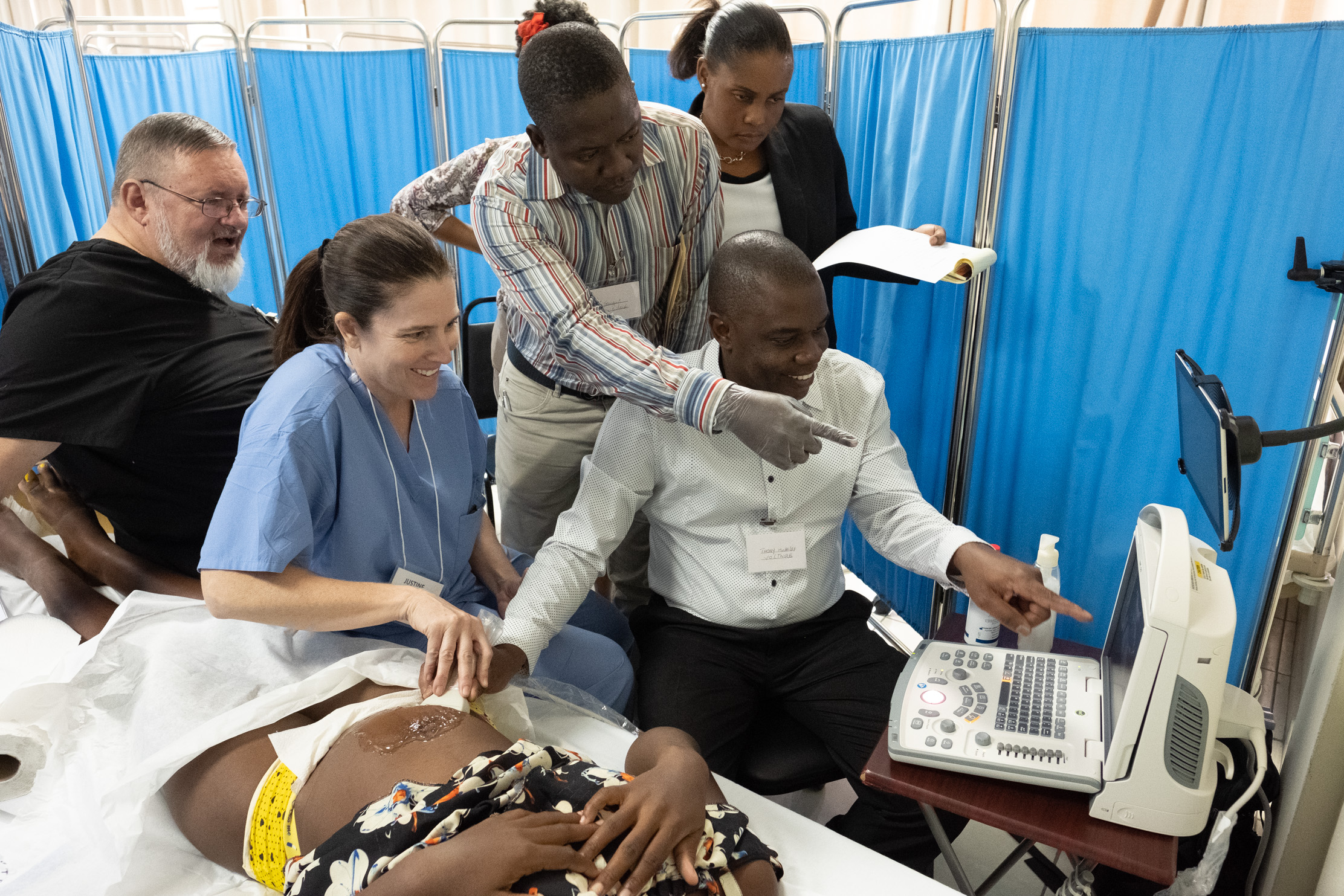 OB/GYN, abdomen, breast, and vascular sonographer, Justine Campbell, helps guide Thony Voltaire’s probe to find the patient’s baby. For most of the patients, and even many of the healthcare providers, this is the first time they’re seeing inside the body with ultrasound.