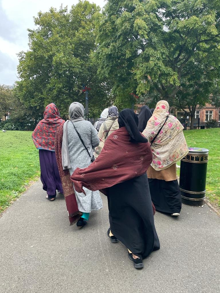 Group_of_seven_women_walking_in_park.jpeg