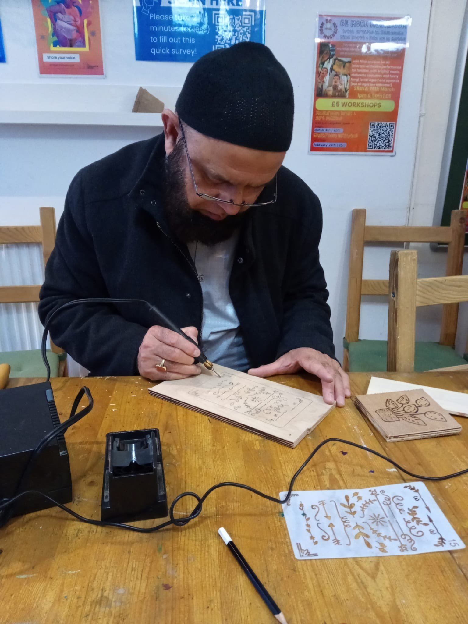 Man wearing black jacket and black hat designing on wood 4.jpeg