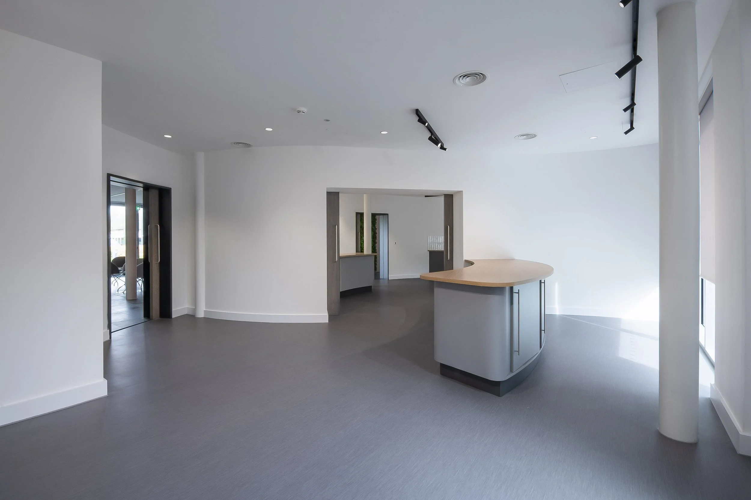 Open-plan room with a blue-grey island unit and timber worktop