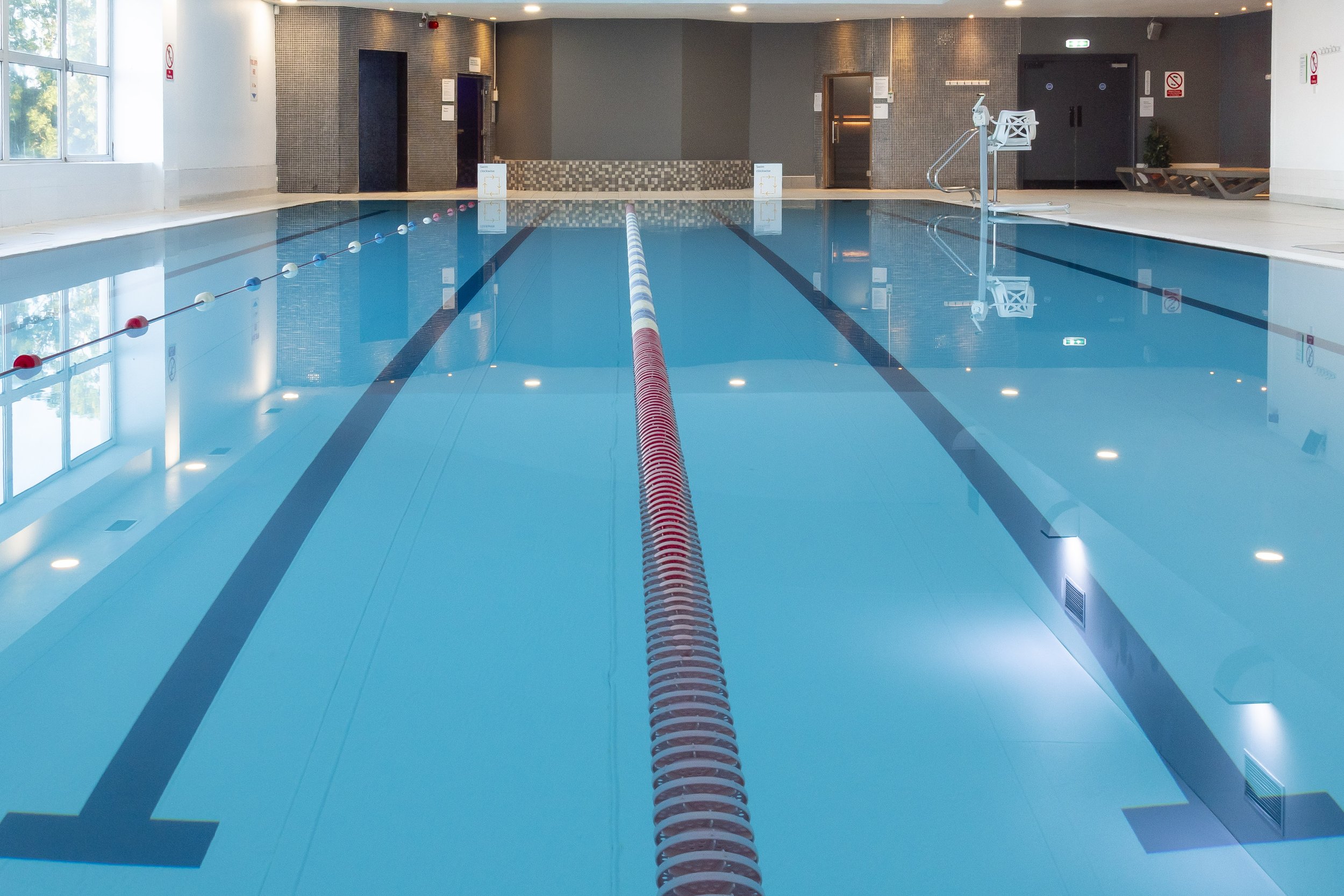 Indoor swimming pool with clear blue water and lane ropes
