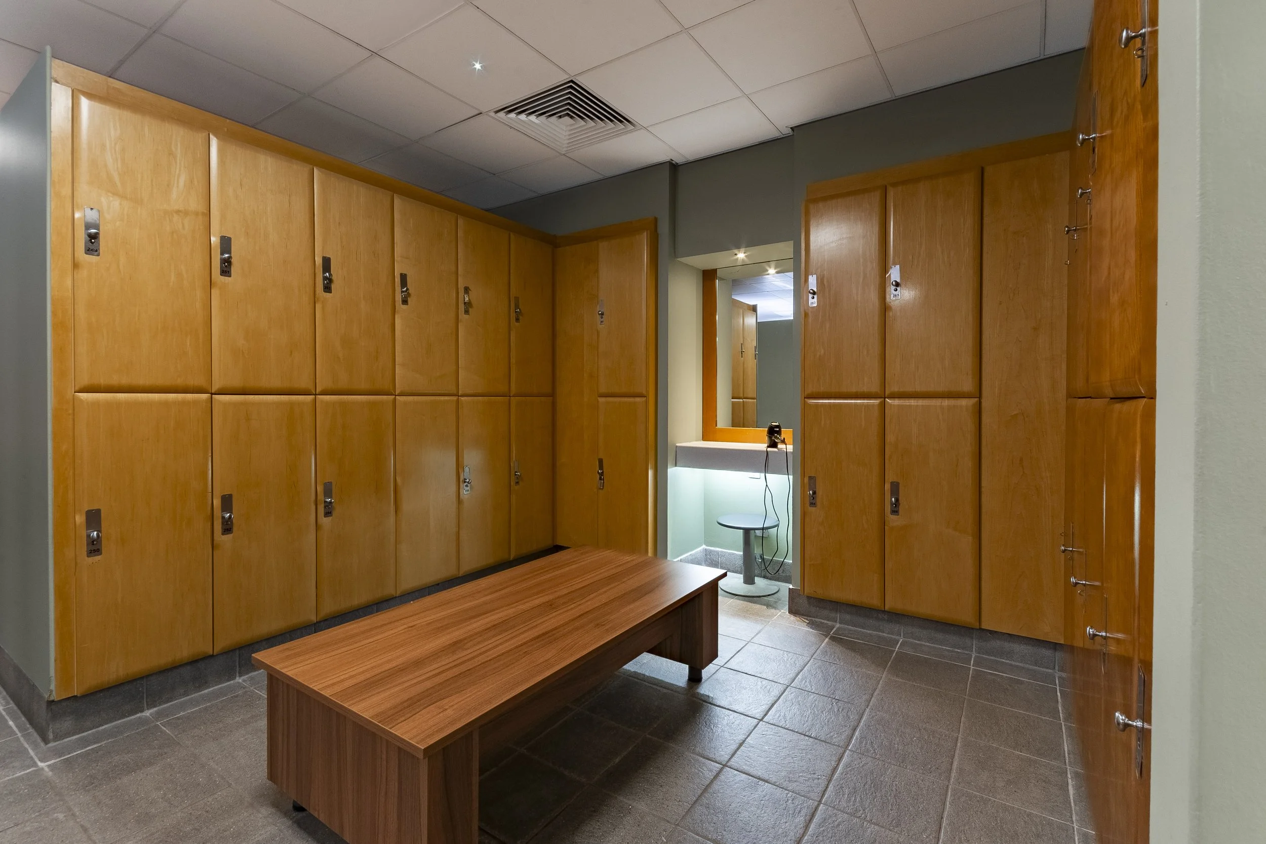 Changing room with wooden lockers and a bench