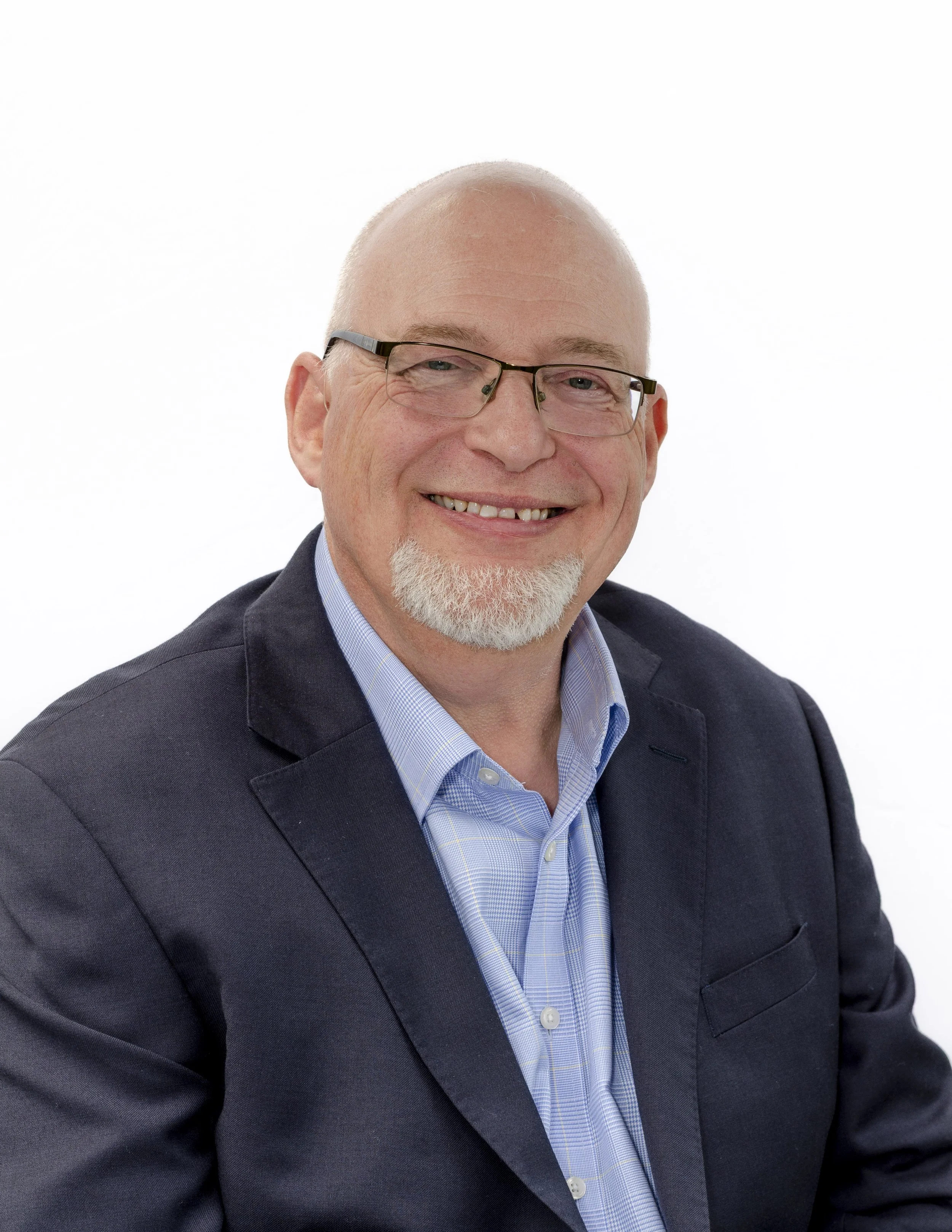 Mark Spence smiling in a navy blazer and blue shirt on a white background