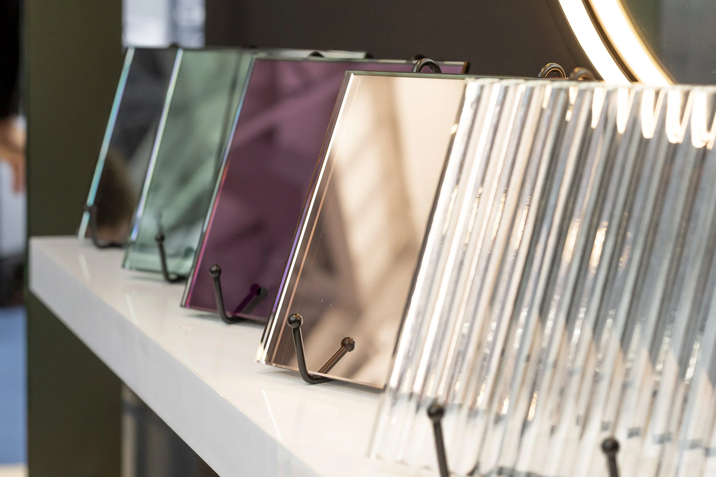 Fluted glass samples in green, purple, bronze and clear on a shelf_Abbey Glass (Cardiff) Limited