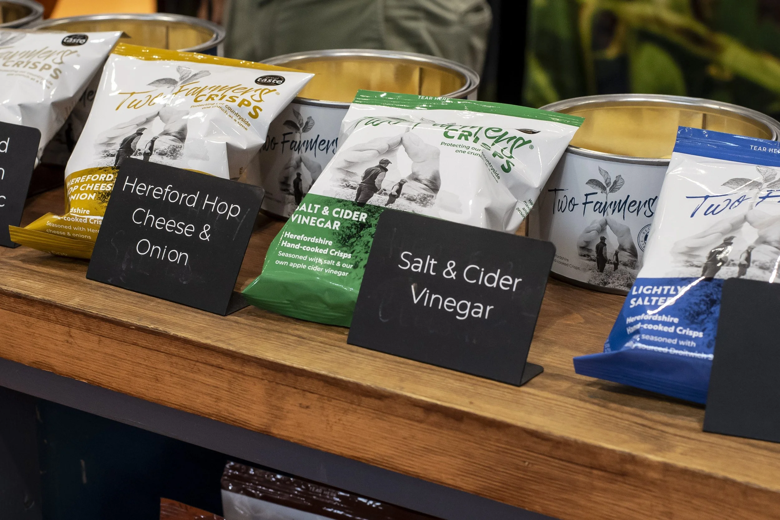 Display of Crisps flavours on a wooden counter with chalkboard flavour signs