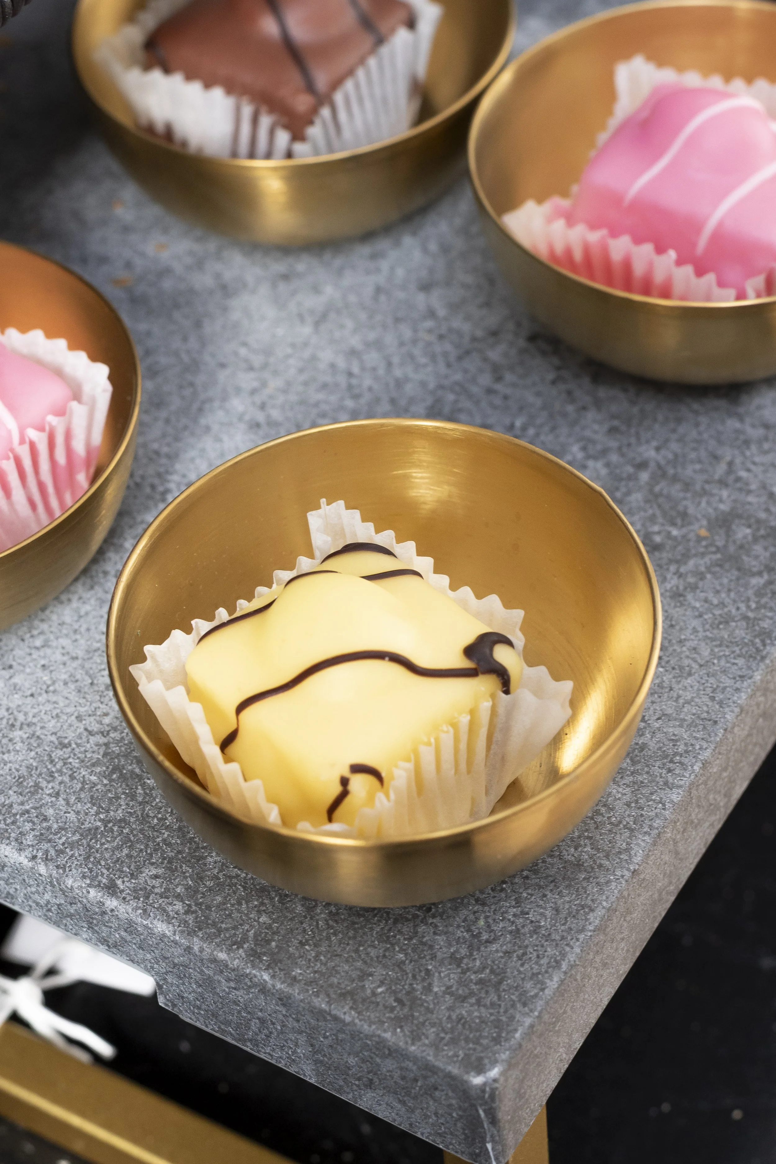 Brass dishes holding pink treats on a grey tray_HG Stephensons Ltd