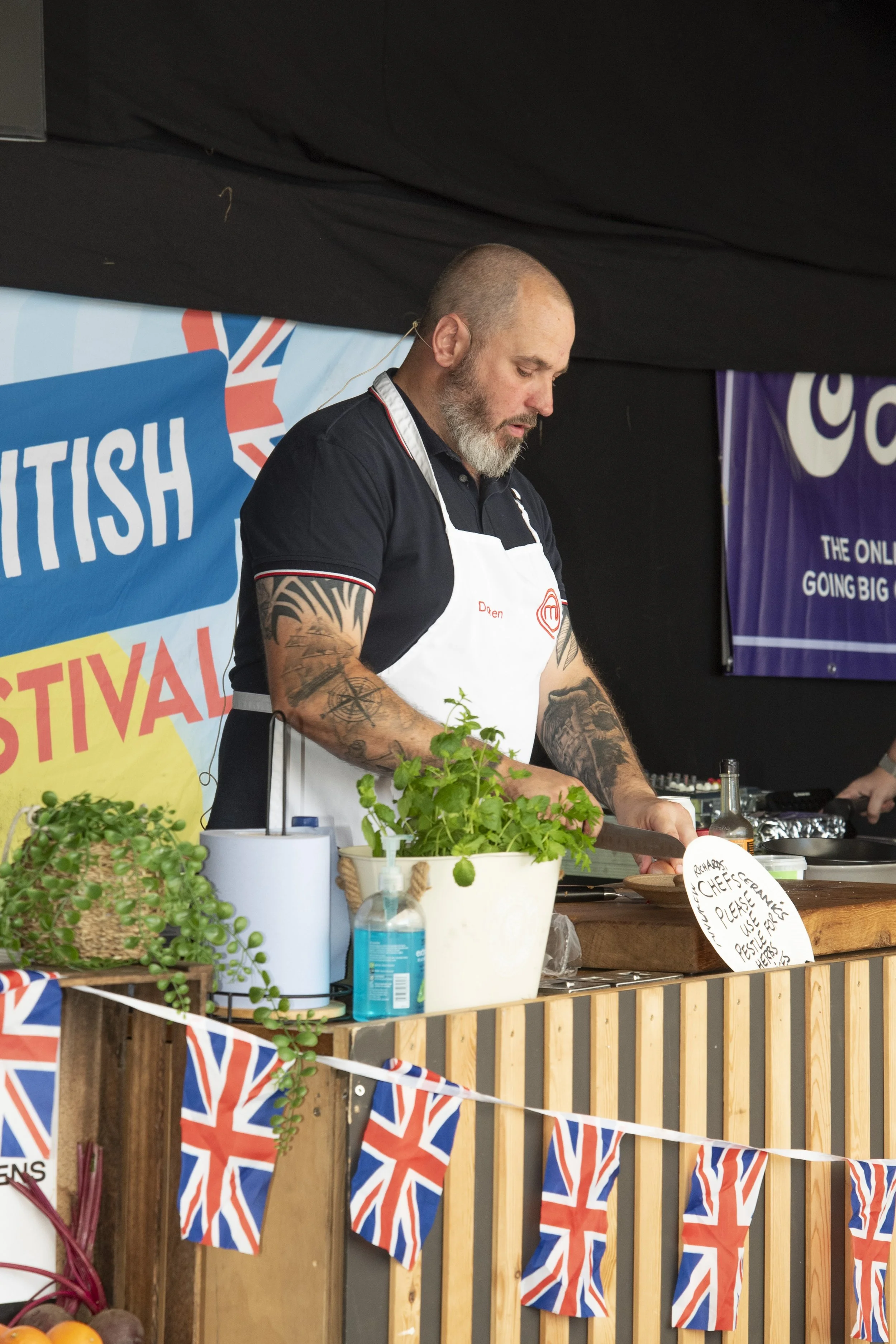 Event food stall vendor demonstrating culinary prep at the Great British Food Festival 