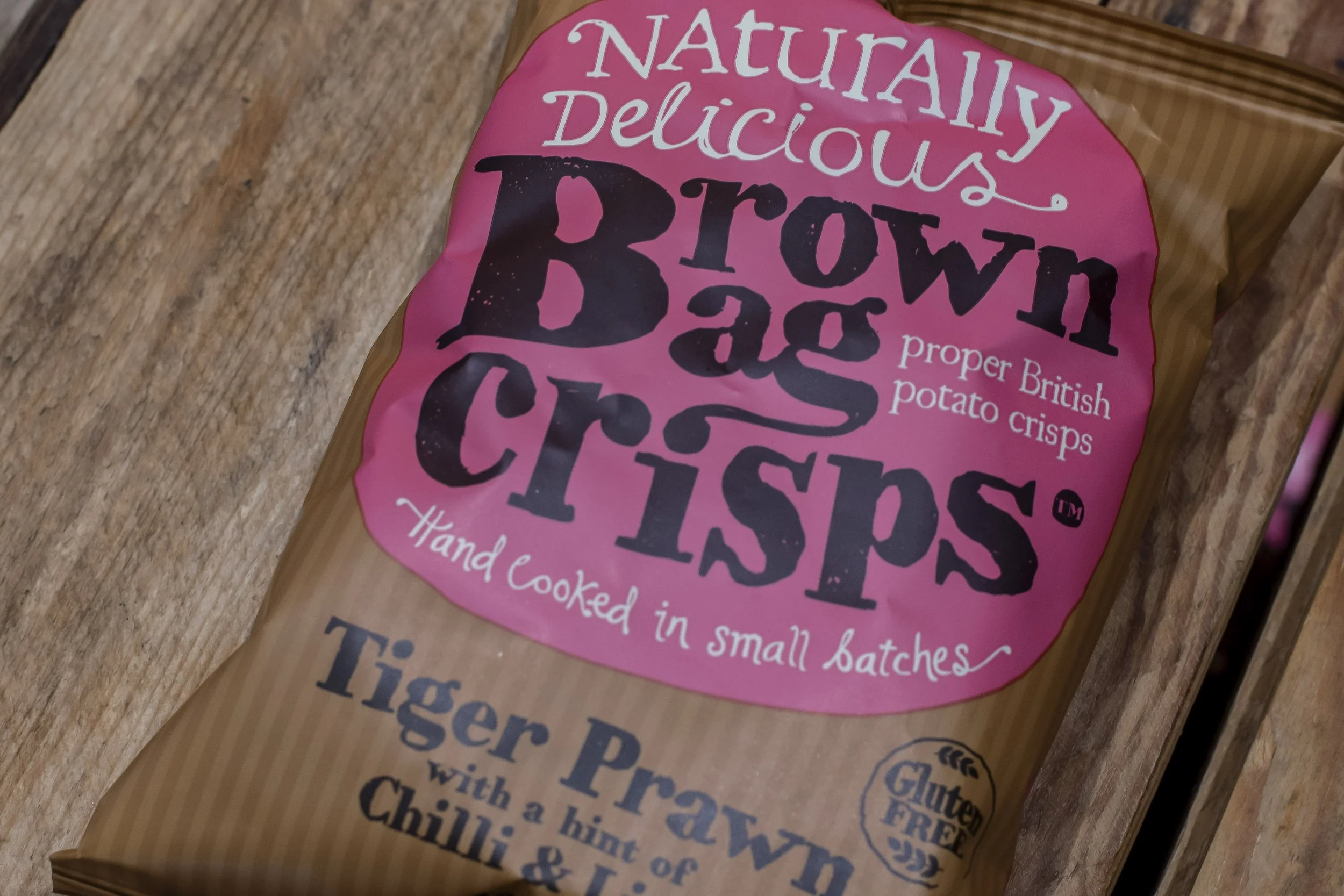 Close-up of a Brown Bag Crisps Tiger Prawn flavour bag on rustic wood