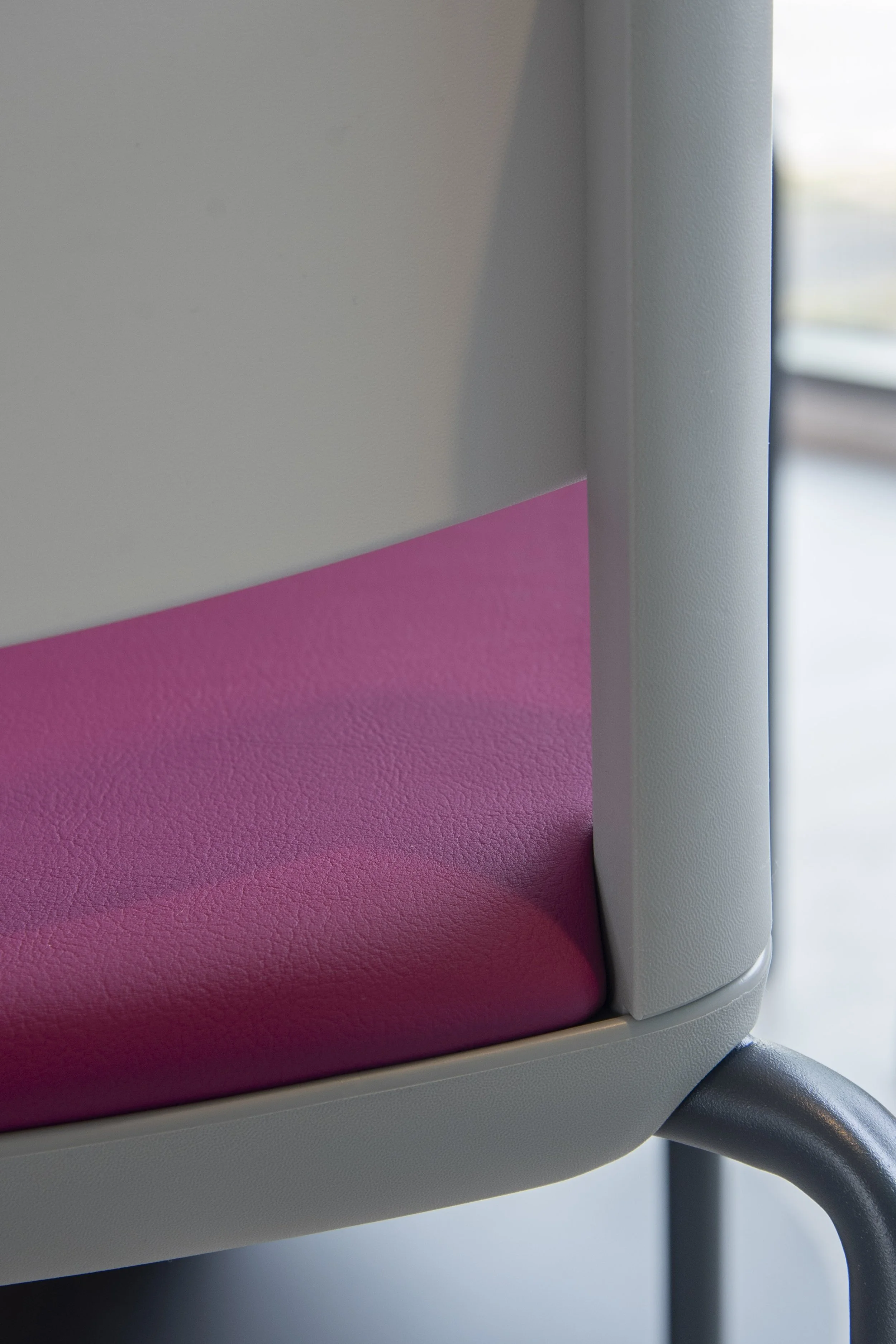 Close-up of a white chair with a pink seat cushion