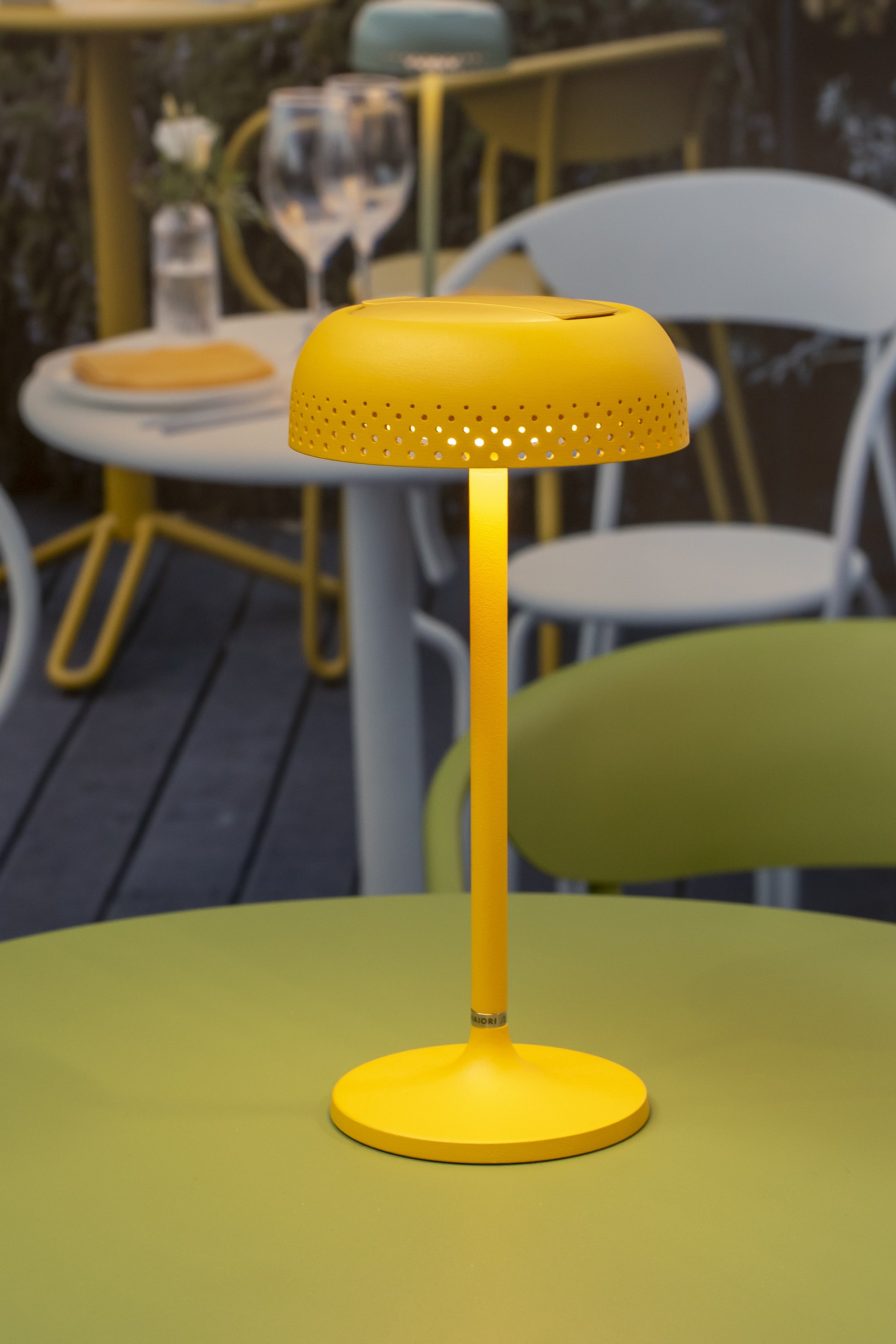Yellow table lamp on a green outdoor table_Lumenform
