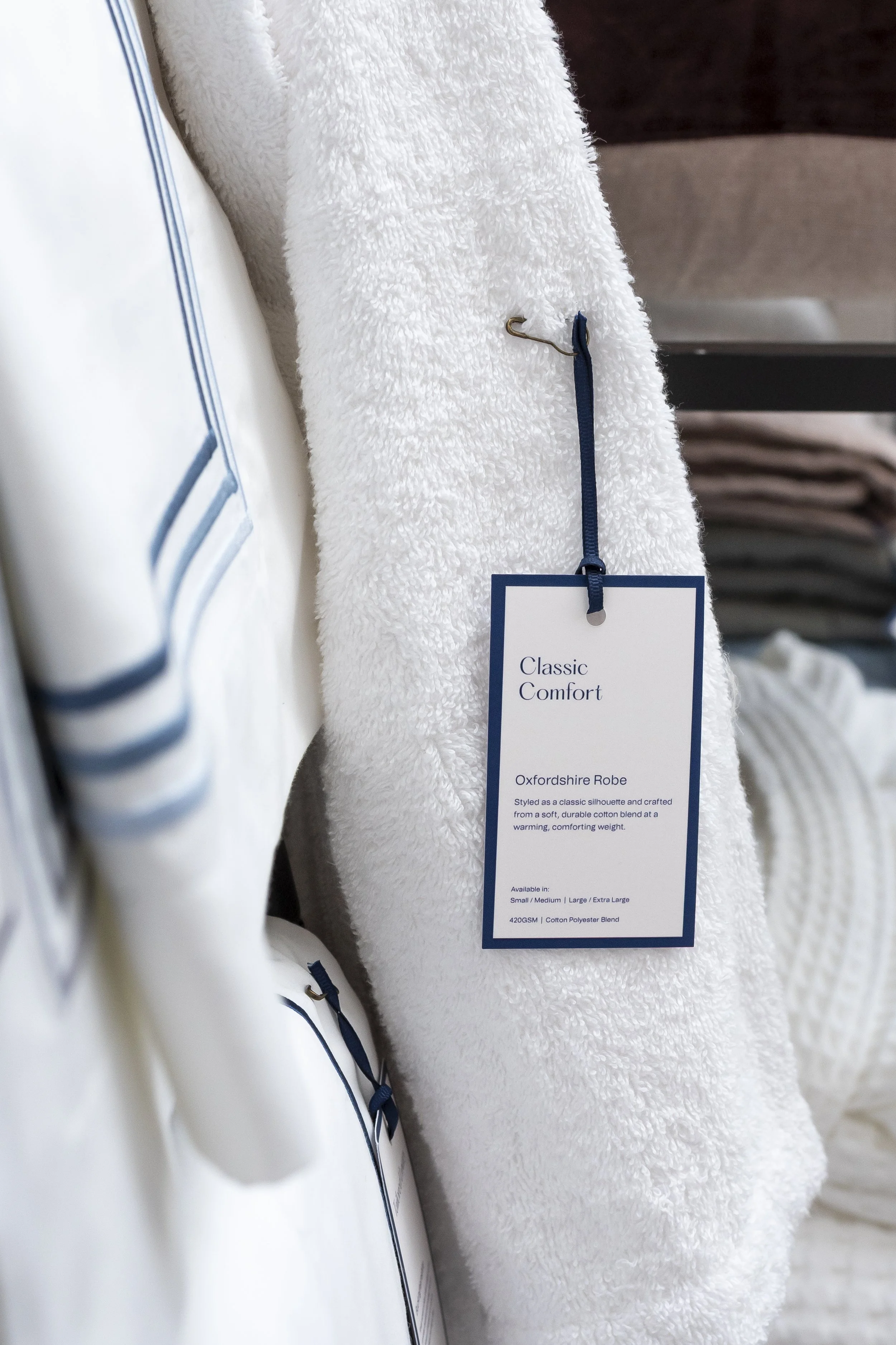White towel with a navy-striped label on a rail_Christy