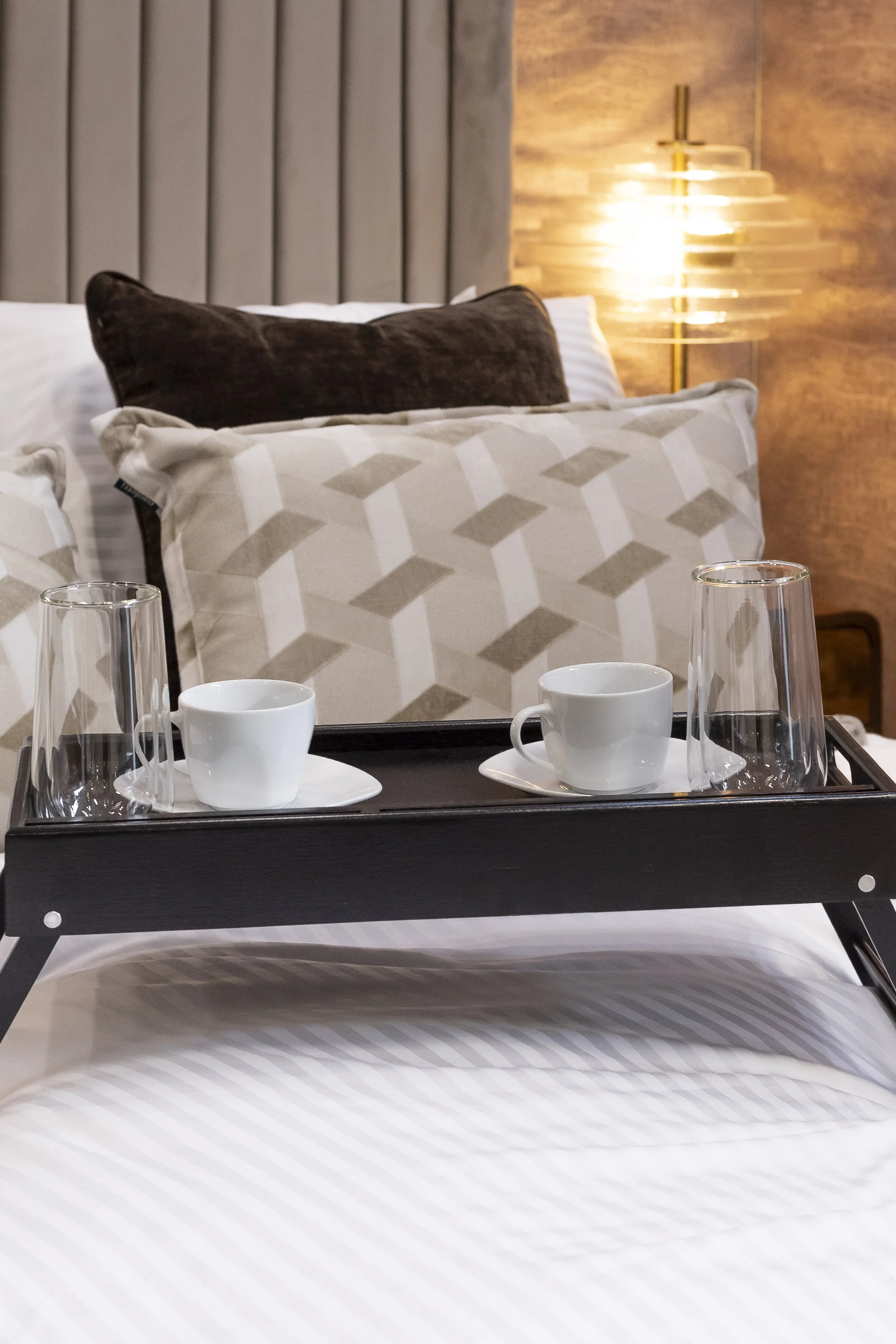 Breakfast tray with cups and glasses on a white bed_Wayfair Professional