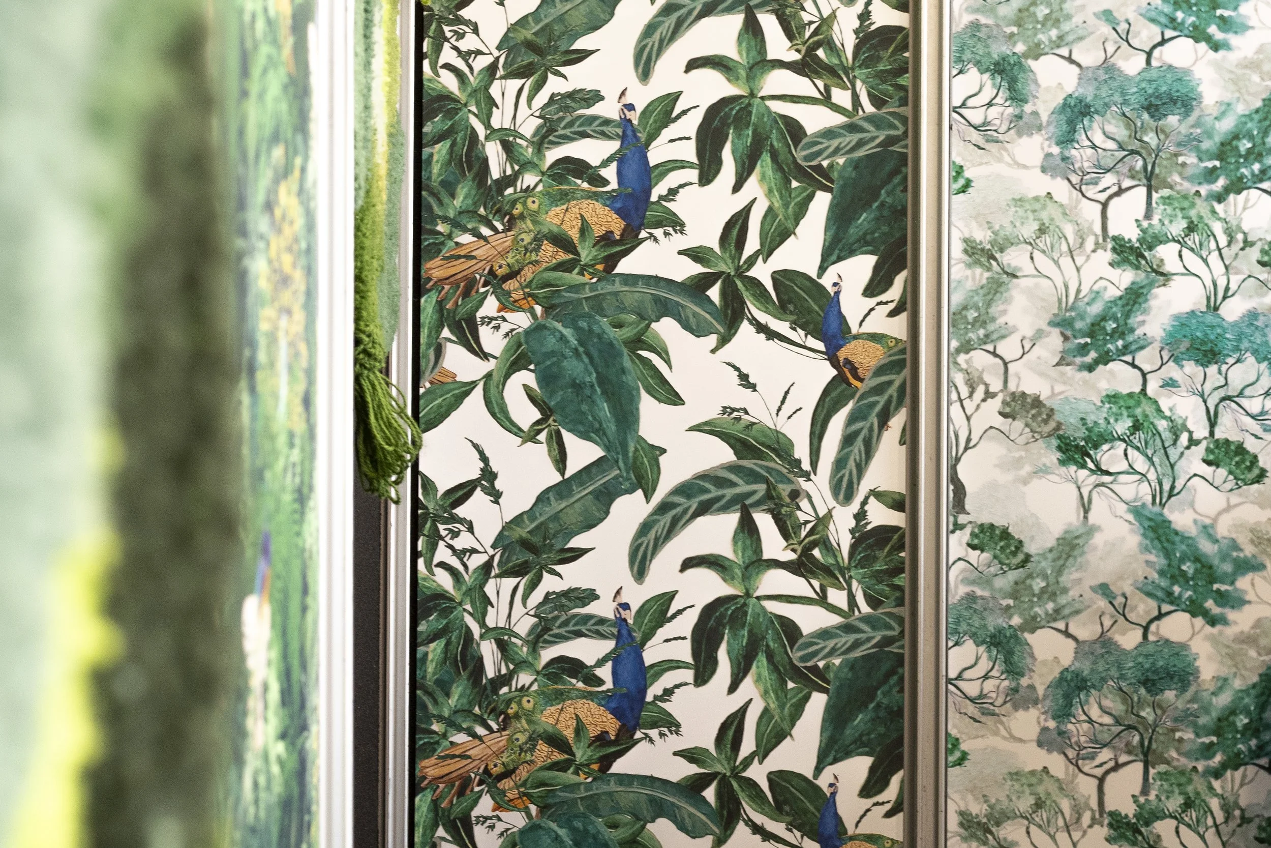 Botanical wallpaper with peacocks among green foliage_Maclure Designs