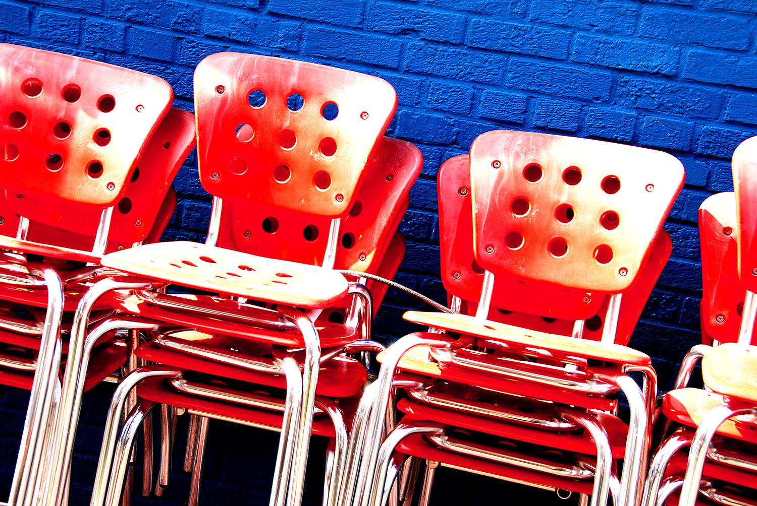 Chairs_Stacked_Orange_Blue_Brick_Wall_Restaurant.jpg