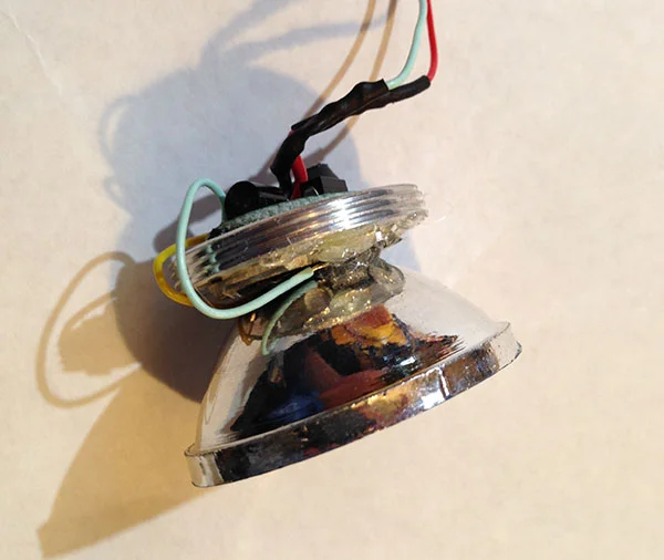 So, I added a piece of aluminum from the donor flashlight as a heatsink. I hot-glued the driver to the bottom of the heatsink (covered it in electrical tape to prevent shorts). I tacked the LED to the heat sink with hot-glue and did the same with the reflector. Before tacking the LED in place I added a bit of thermal compound to the bottom of the LED for good measure.