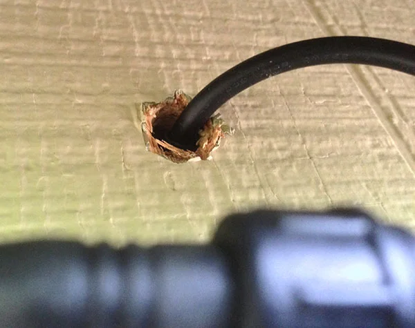 The cable coming out of the wall of the house (shown before caulking was added).