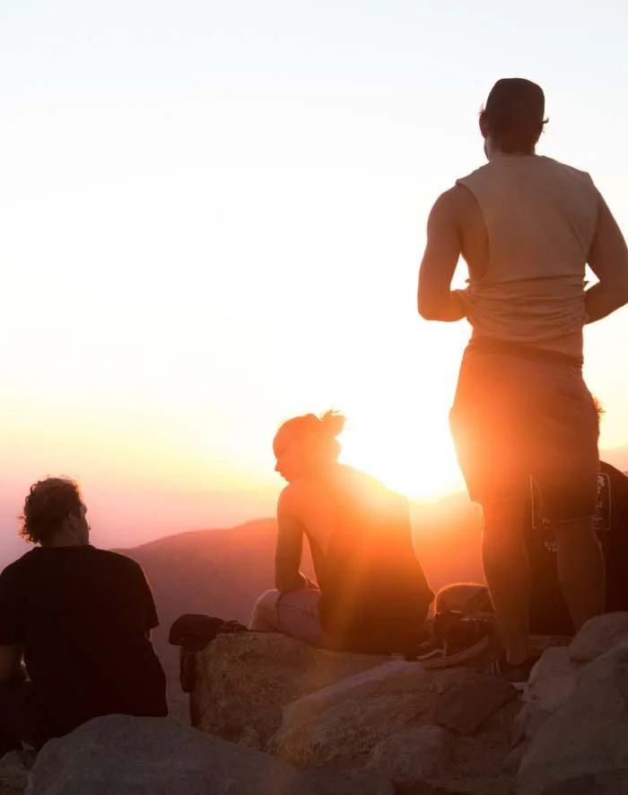 Group of men talking and listening sitting in nature on a mountain top central coast australia