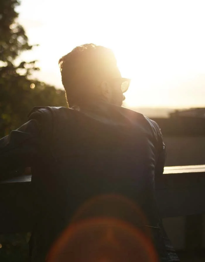 mens counselling outdoors with man looking to distance in afternoon light