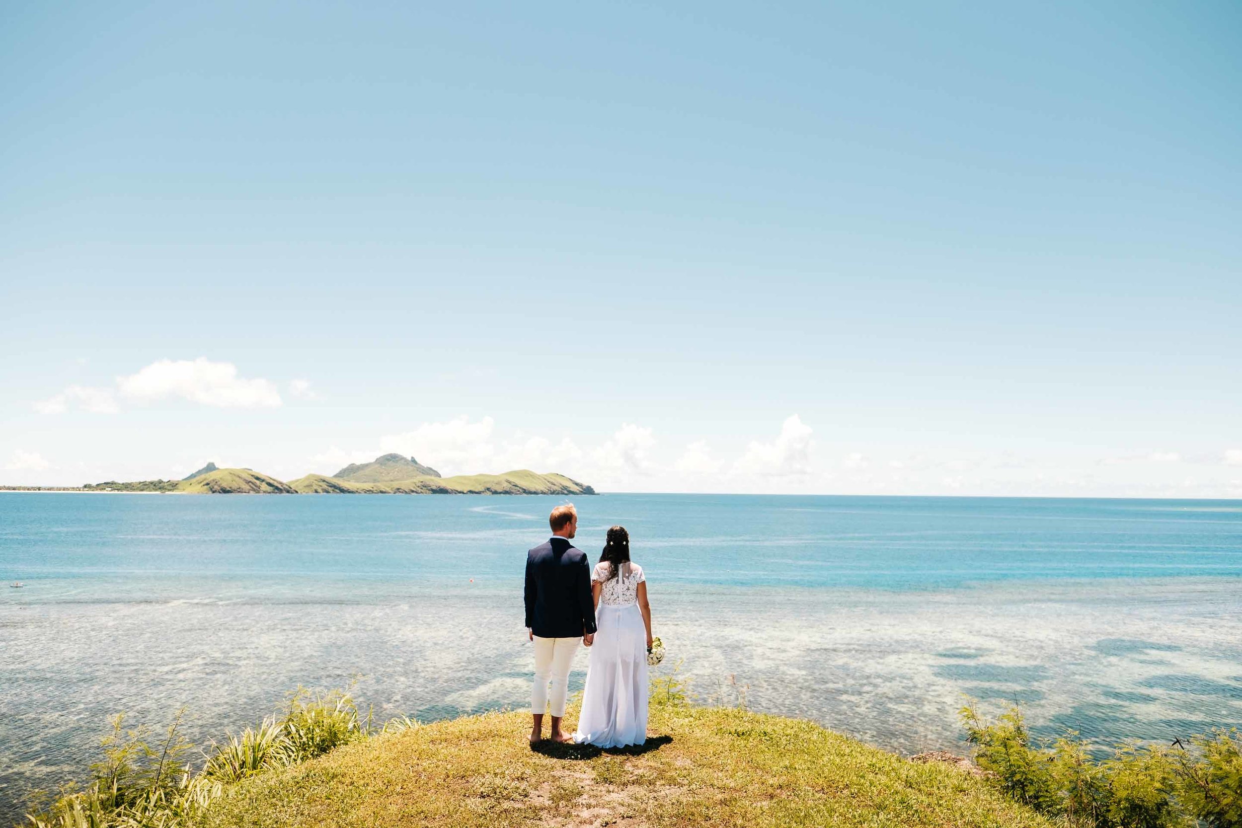 the newlyweds at a lookout pint above the Mamanuca seas of the South Pacific