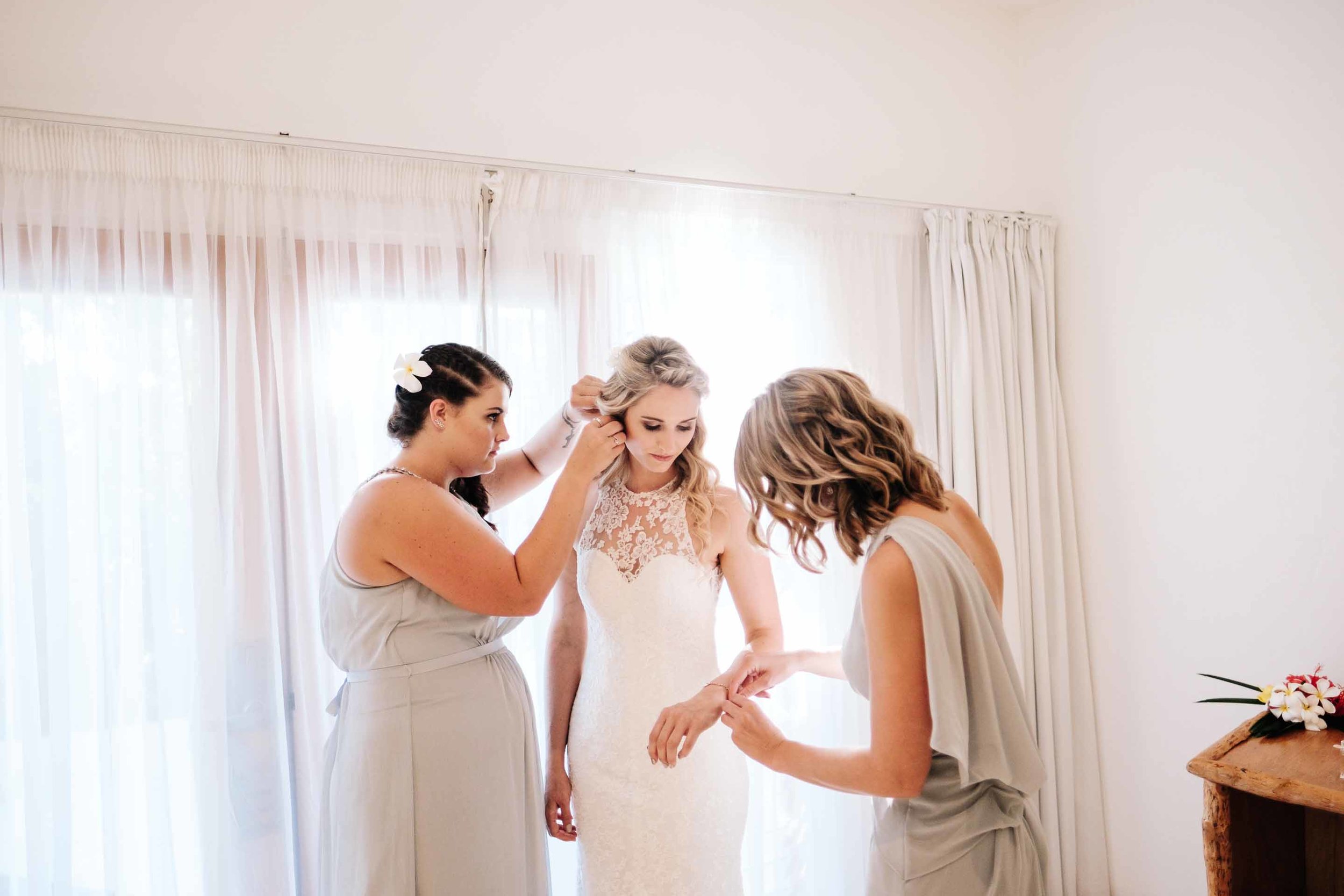 the bridesmaids helping the bride with her jewellery