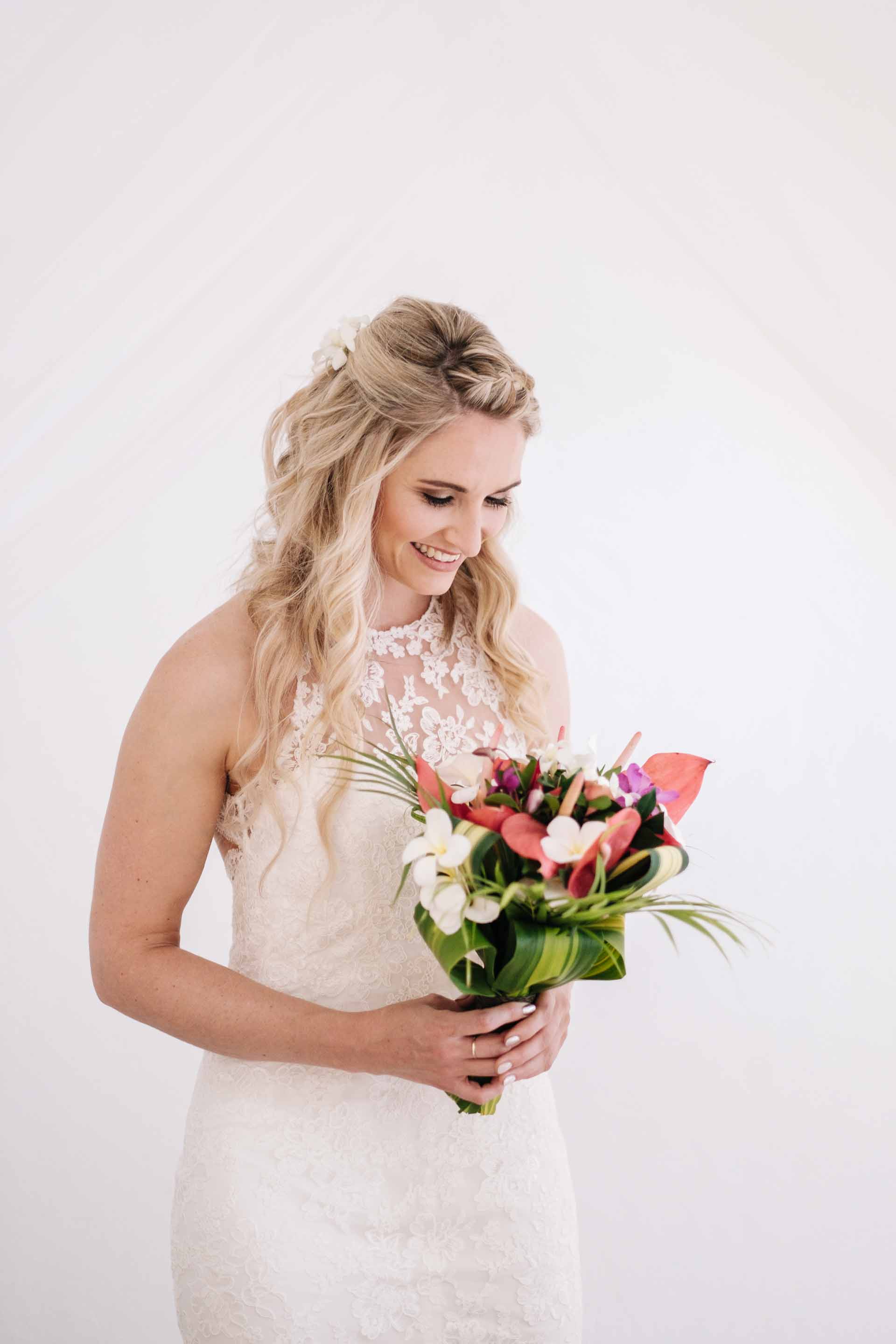 a portrait of the bride Holly with her bridal bouquet by her bed