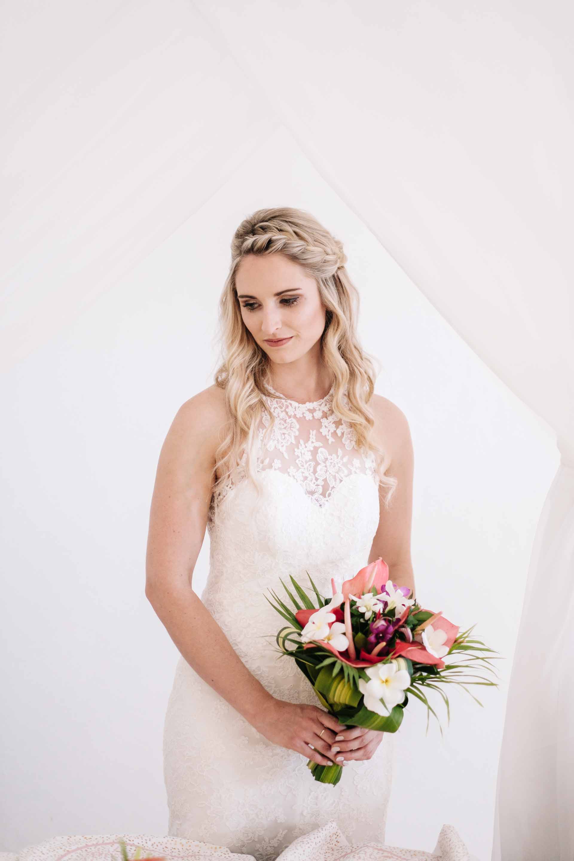 a portrait of the bride Holly with her bridal bouquet by her bed with her faced turned in the opposite direction